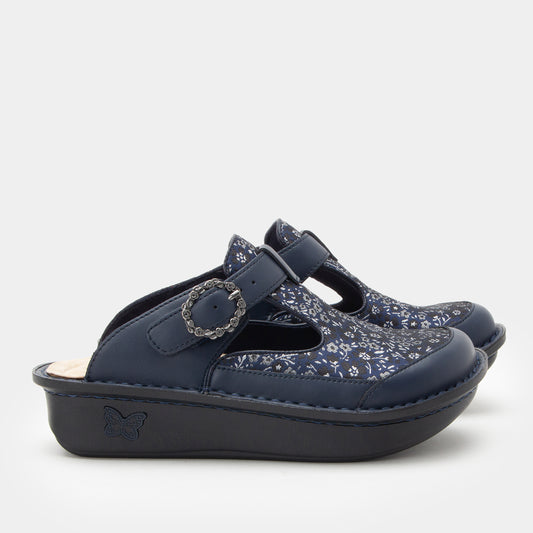 Navy blue clogs with floral pattern on a light gray background