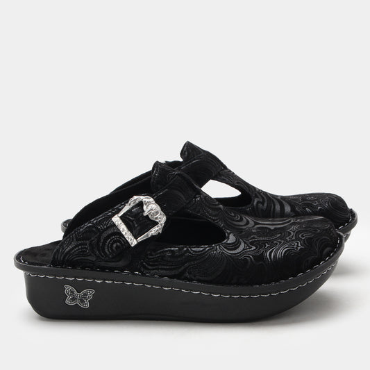Black clogs with floral patterns and a decorative buckle on a white background