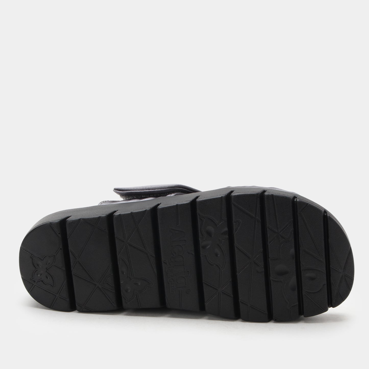 Black sandal sole with tread pattern on a light gray background