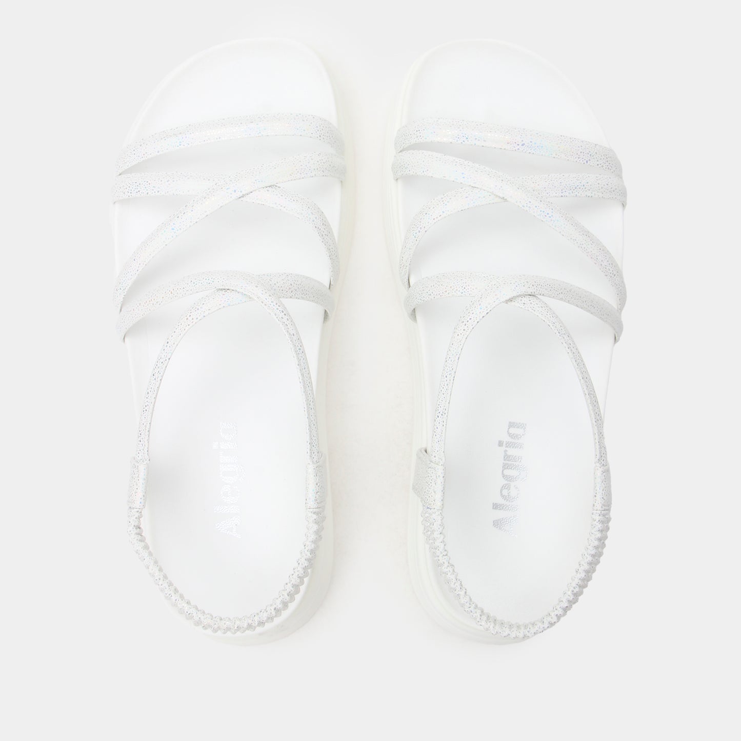 White baby booties with brand name on a light gray background