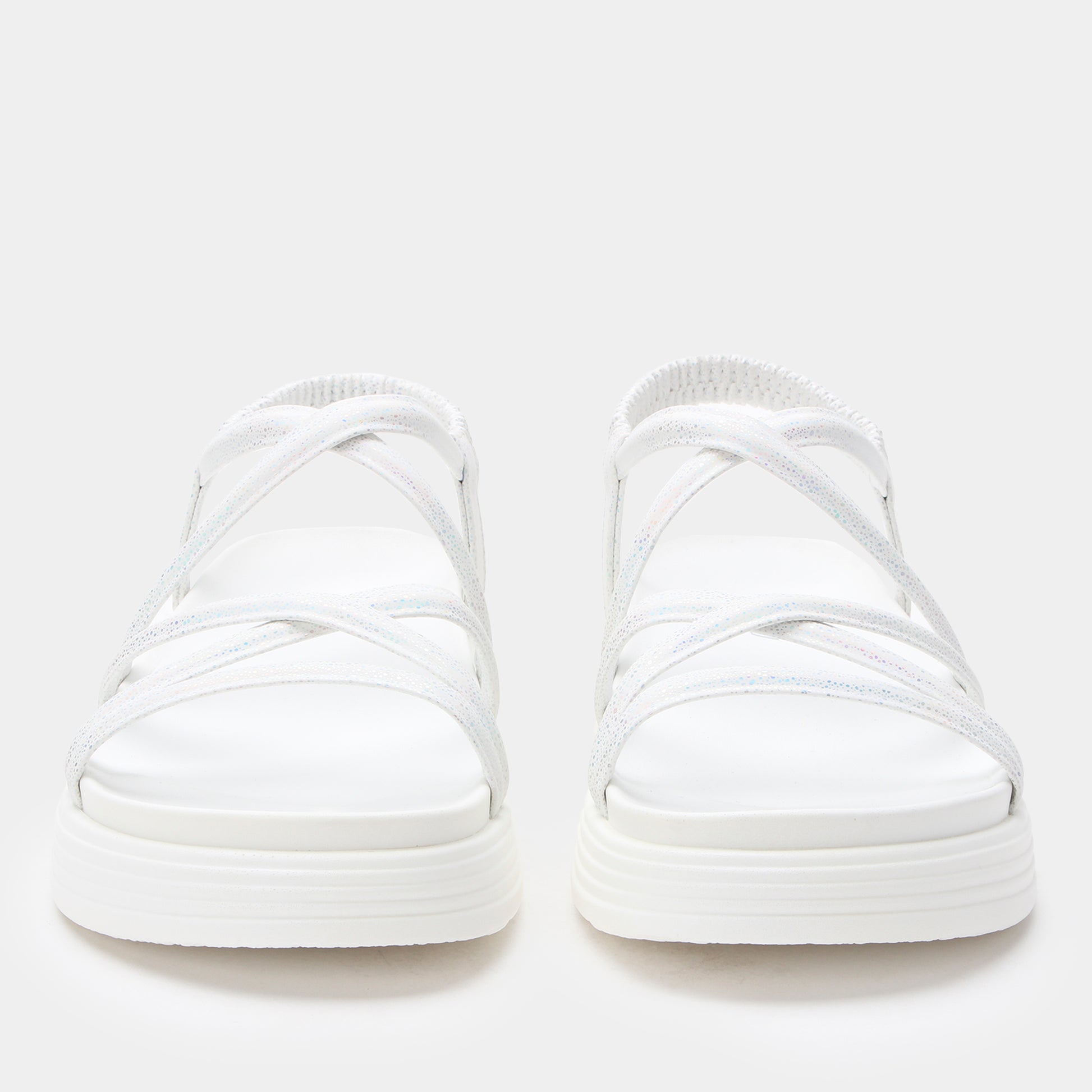 Pair of white slip-on sneakers on a light gray background