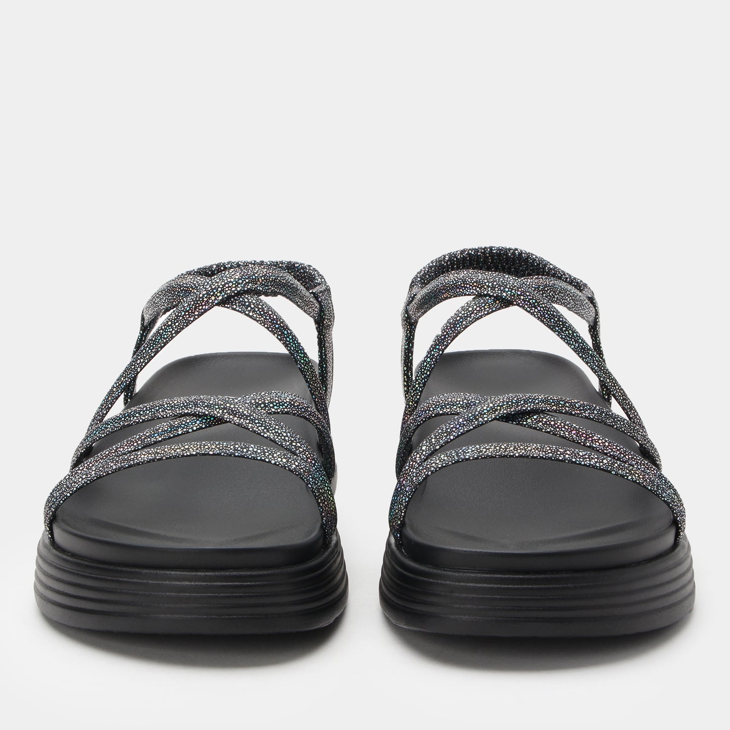 Pair of black sandals with glittery straps on a white background