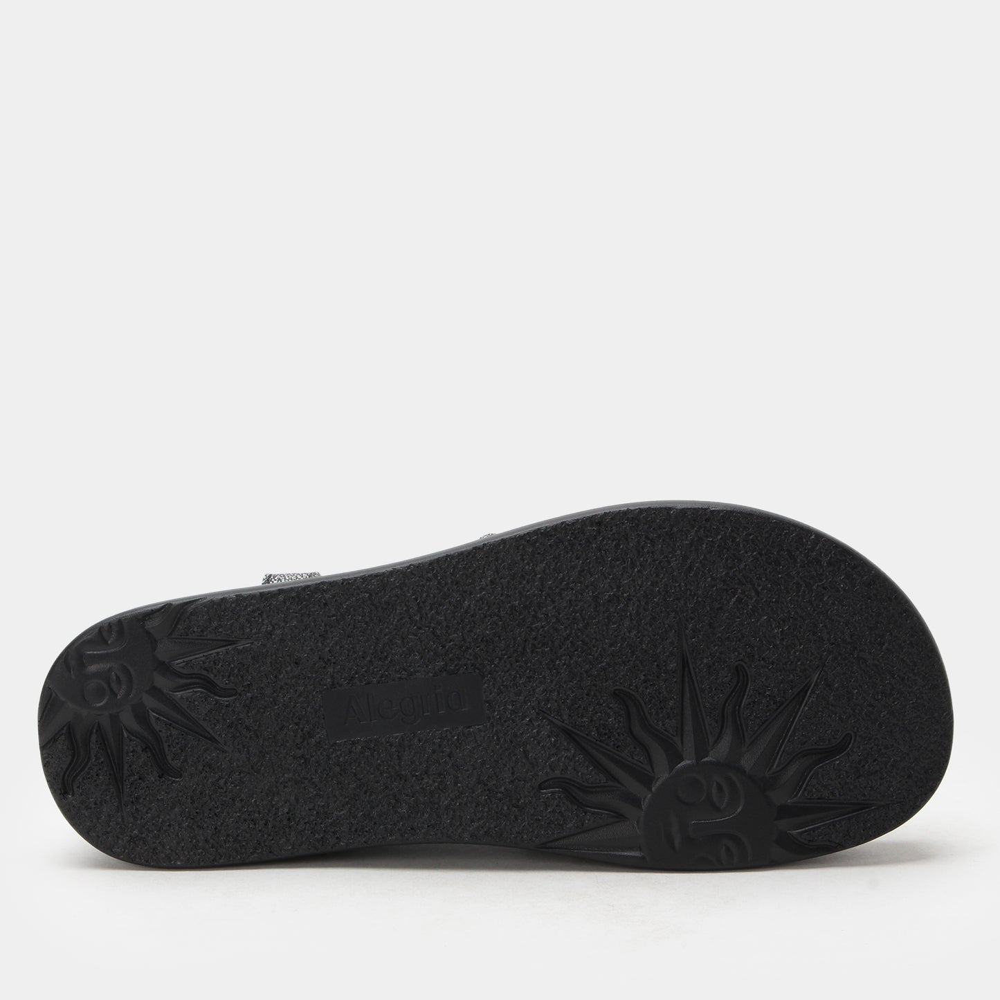 Black sandal sole with textured pattern on a light gray background