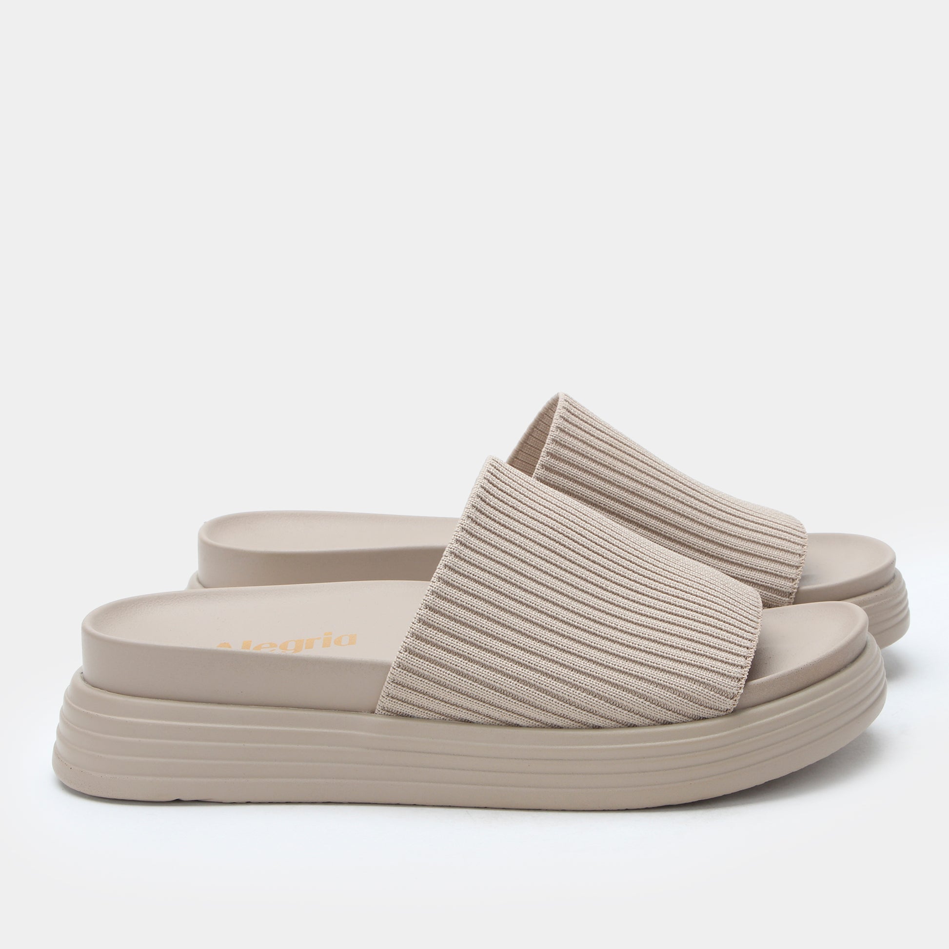 Beige sandals with ribbed straps on a white background