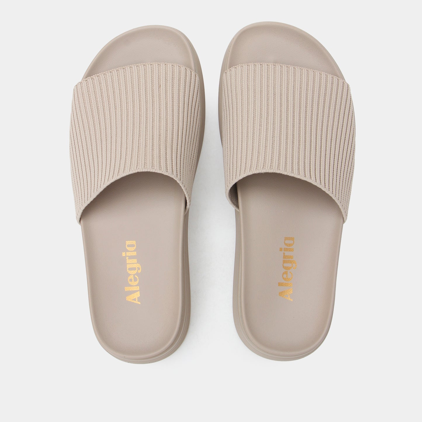 Pair of beige slides with ribbed texture on a white background