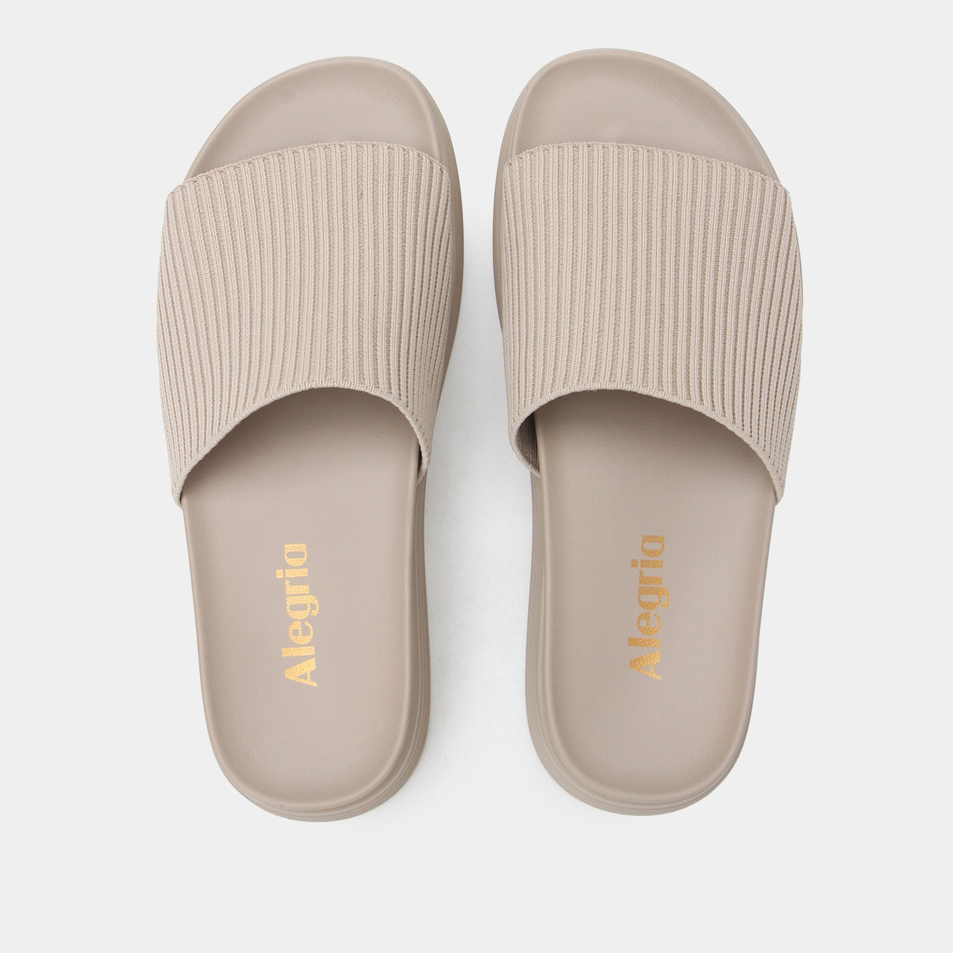 Pair of beige slides with ribbed texture on a white background