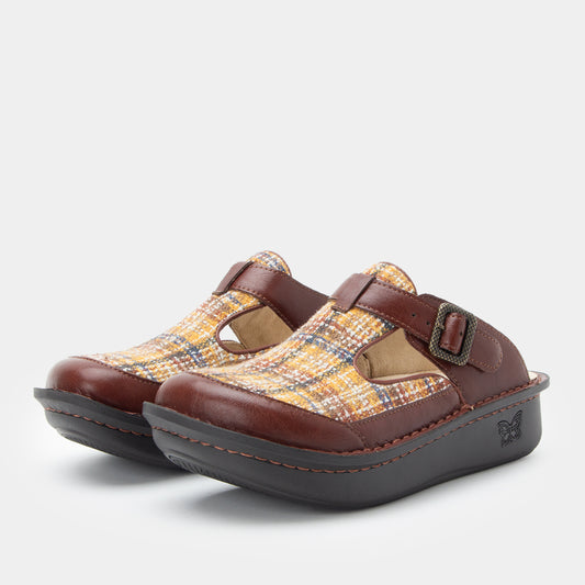 Pair of brown and yellow patterned clogs on a white background