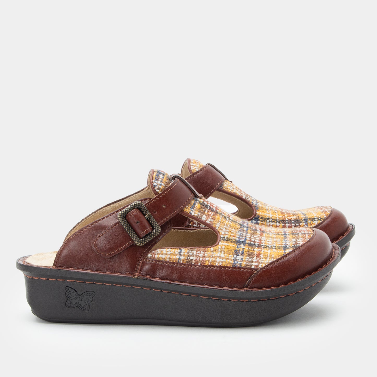Child's clog with plaid pattern and brown buckle on a light gray background
