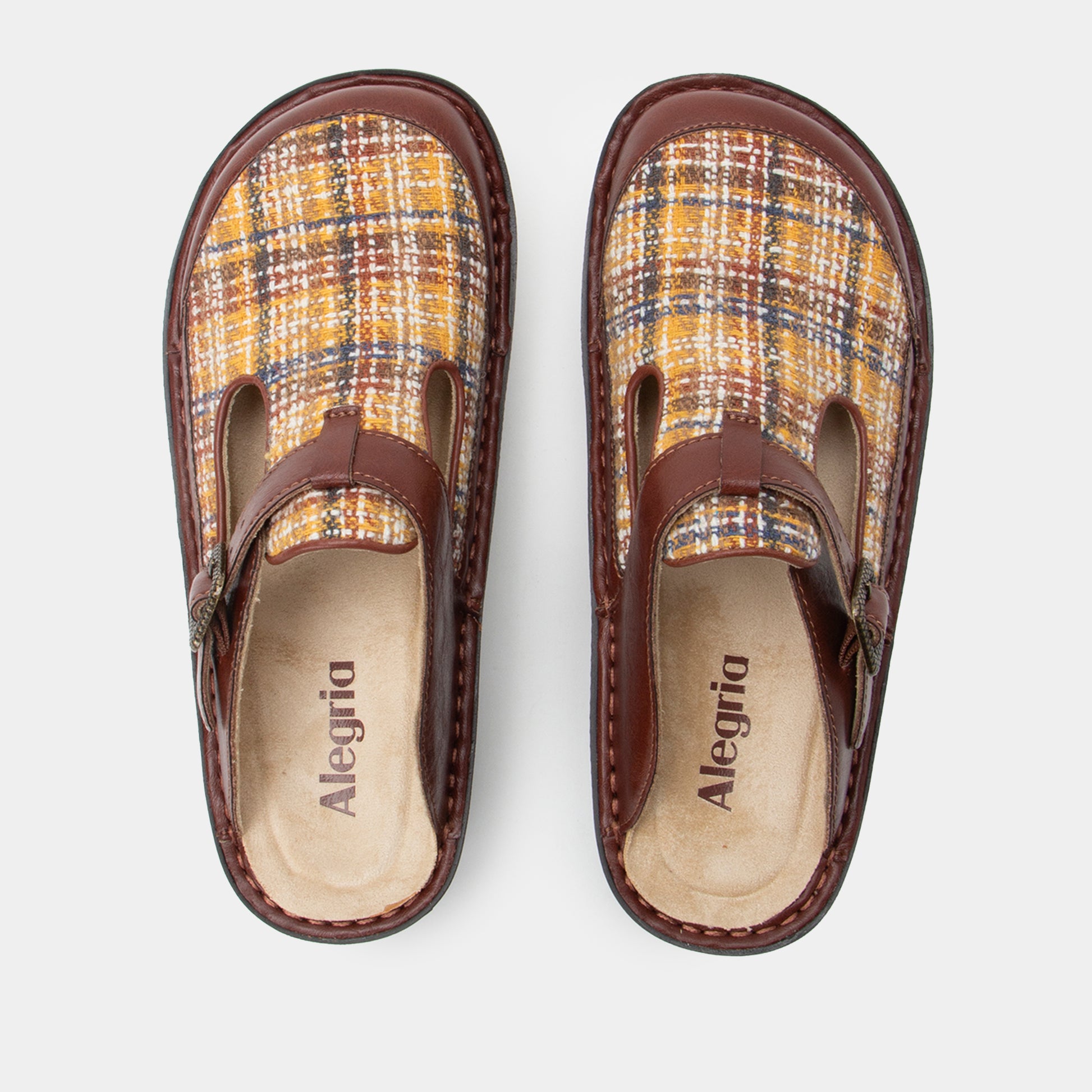 Pair of plaid clogs with brown accents on a white background