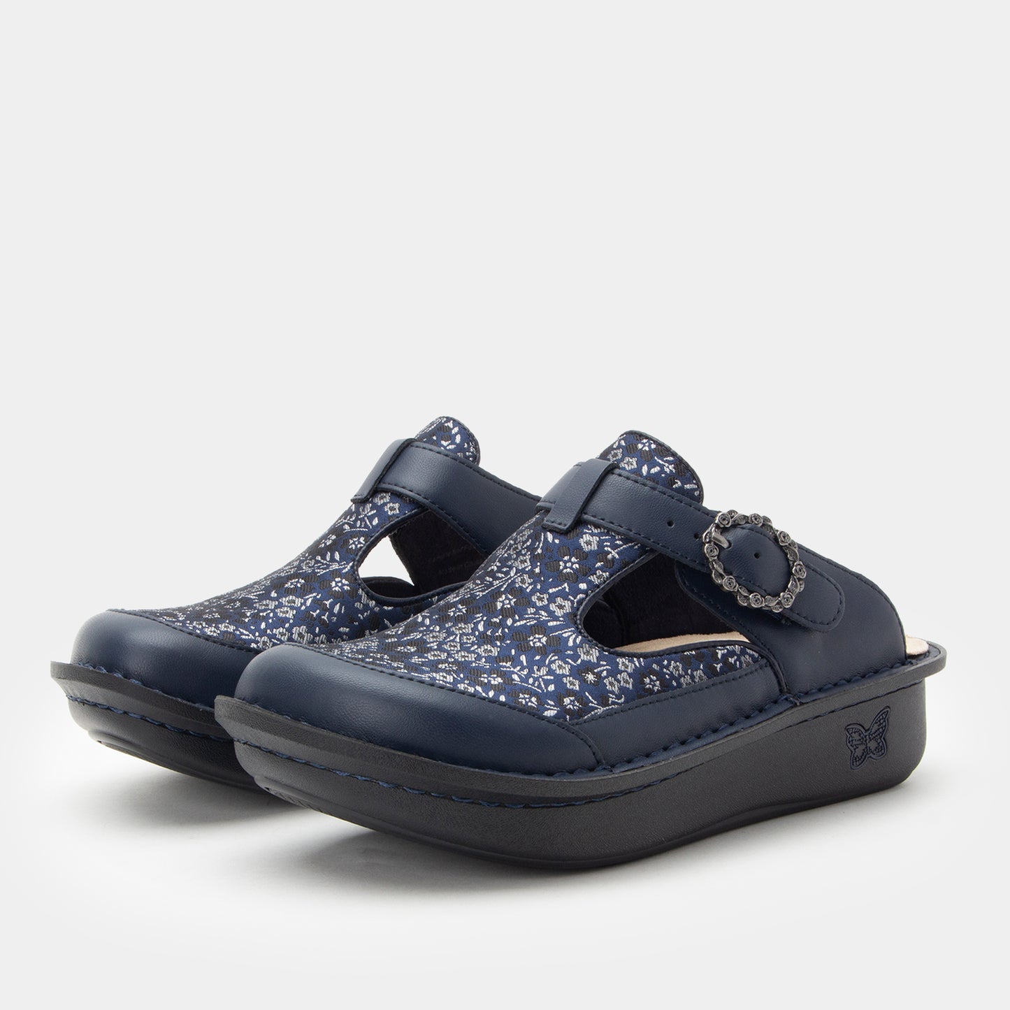 Pair of navy clogs with floral pattern on a white background