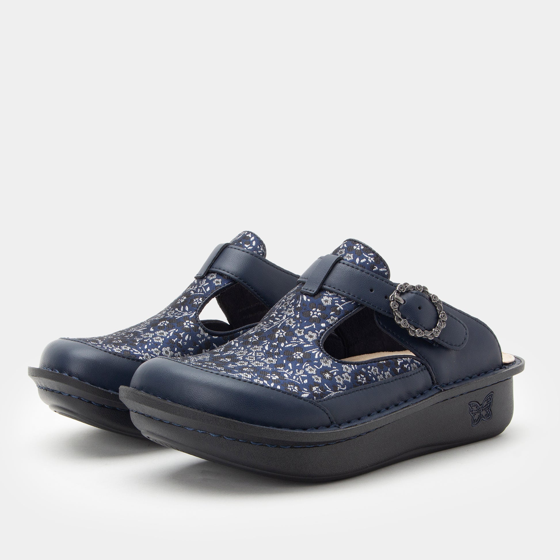 Pair of navy clogs with floral pattern on a white background