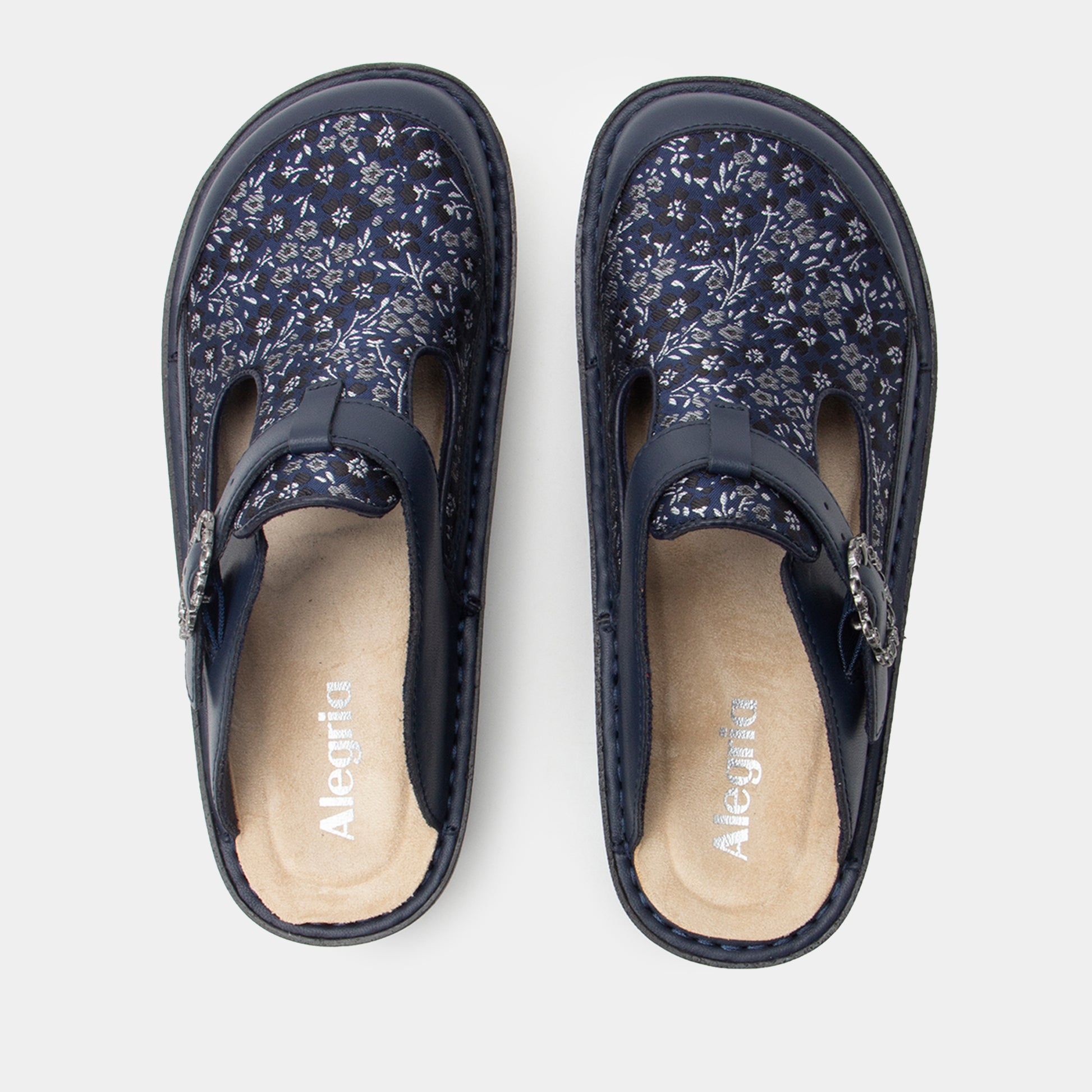 Pair of navy floral-patterned clogss on a white background