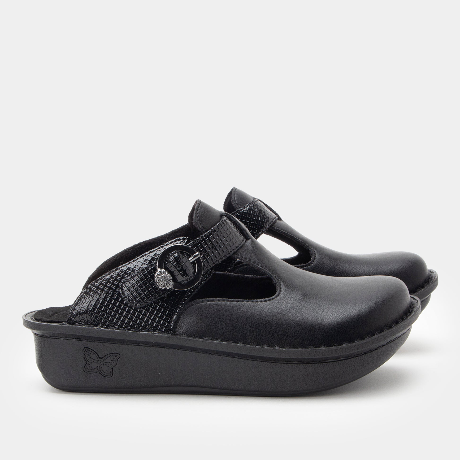 Black clog shoe with a strap on a white background