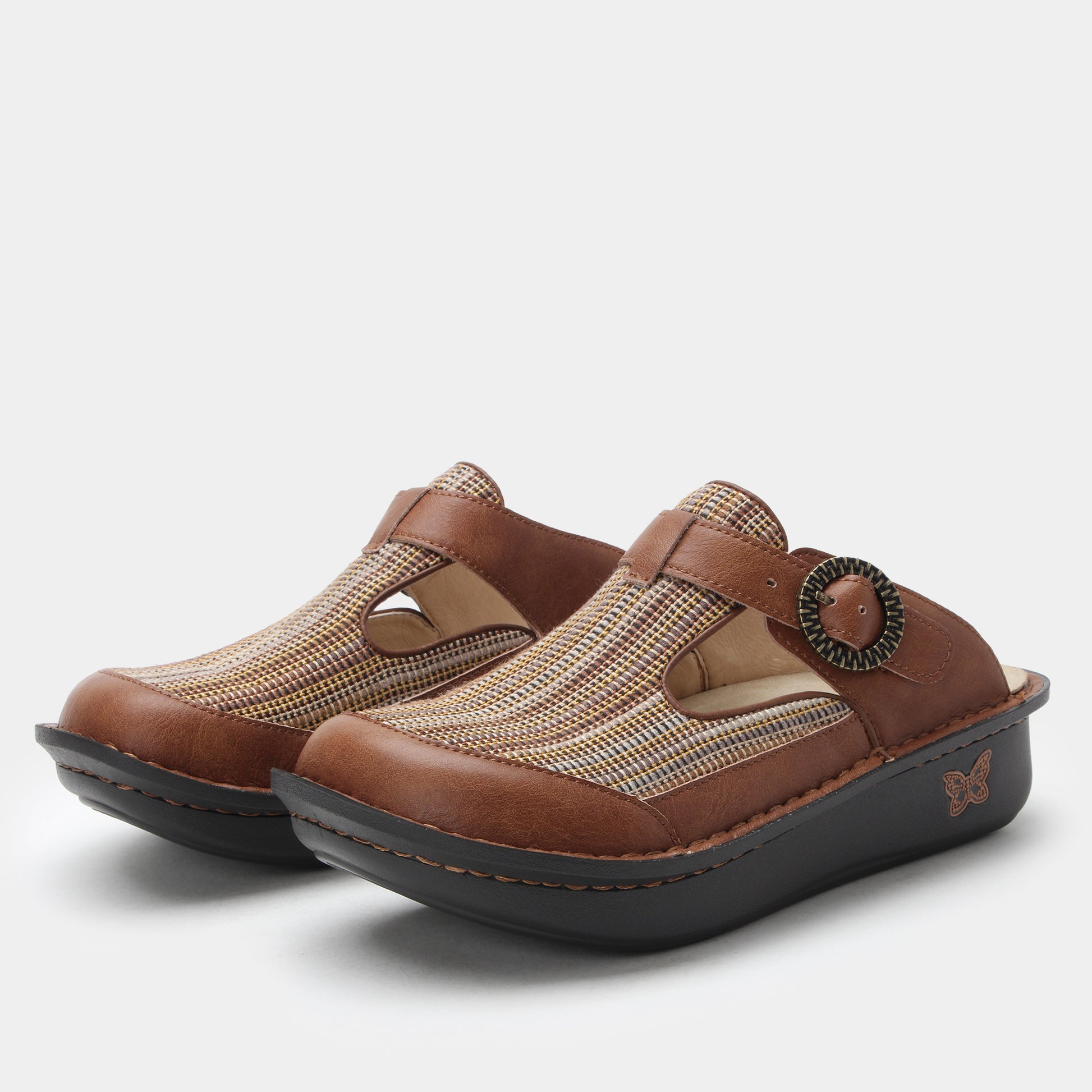 Pair of brown clogs with a textured strap on a white background
