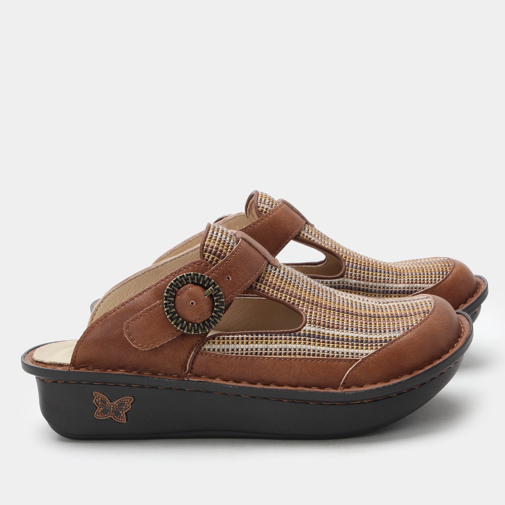 Pair of brown clogs with a decorative buckle on a white background