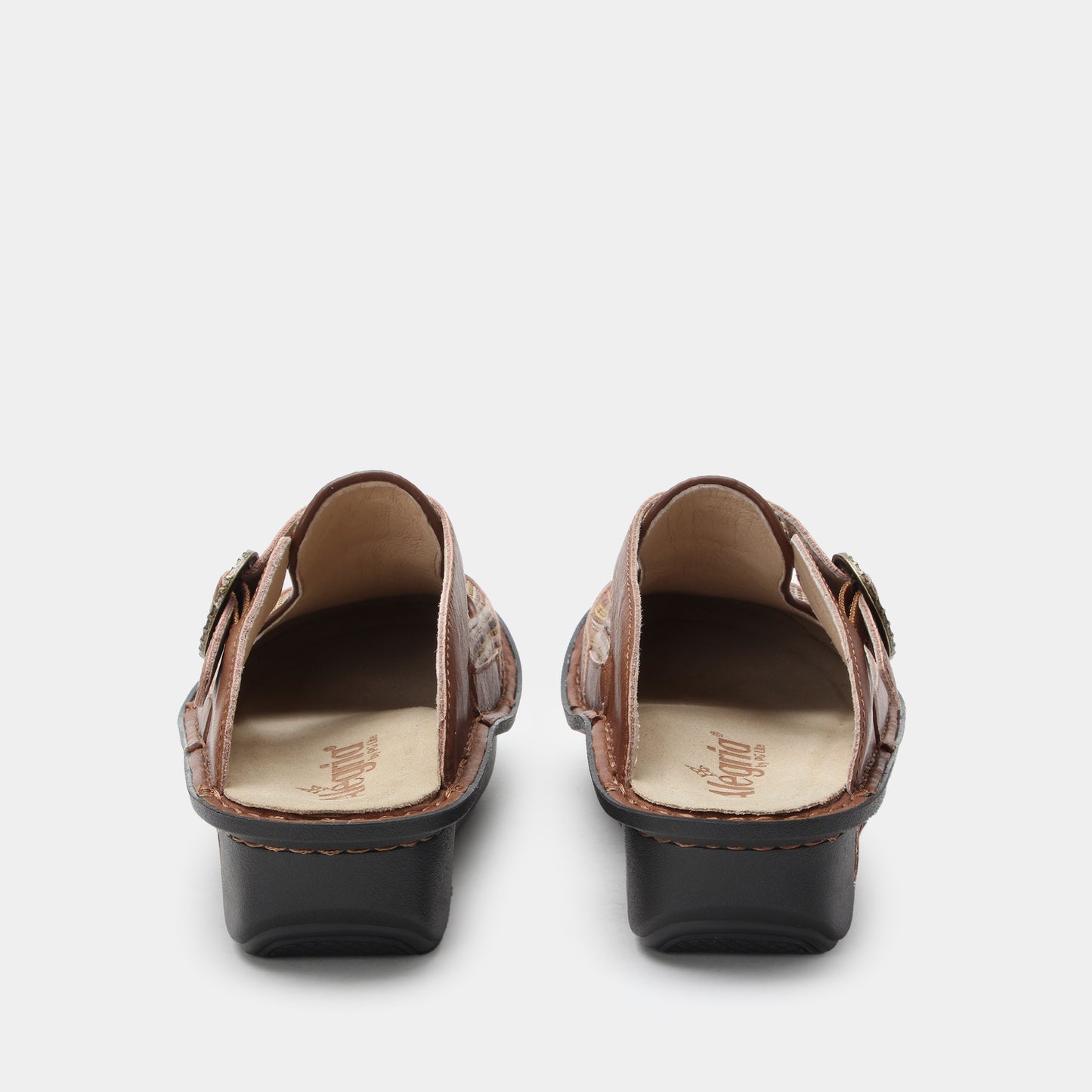 Pair of brown clogs with buckles on a white background