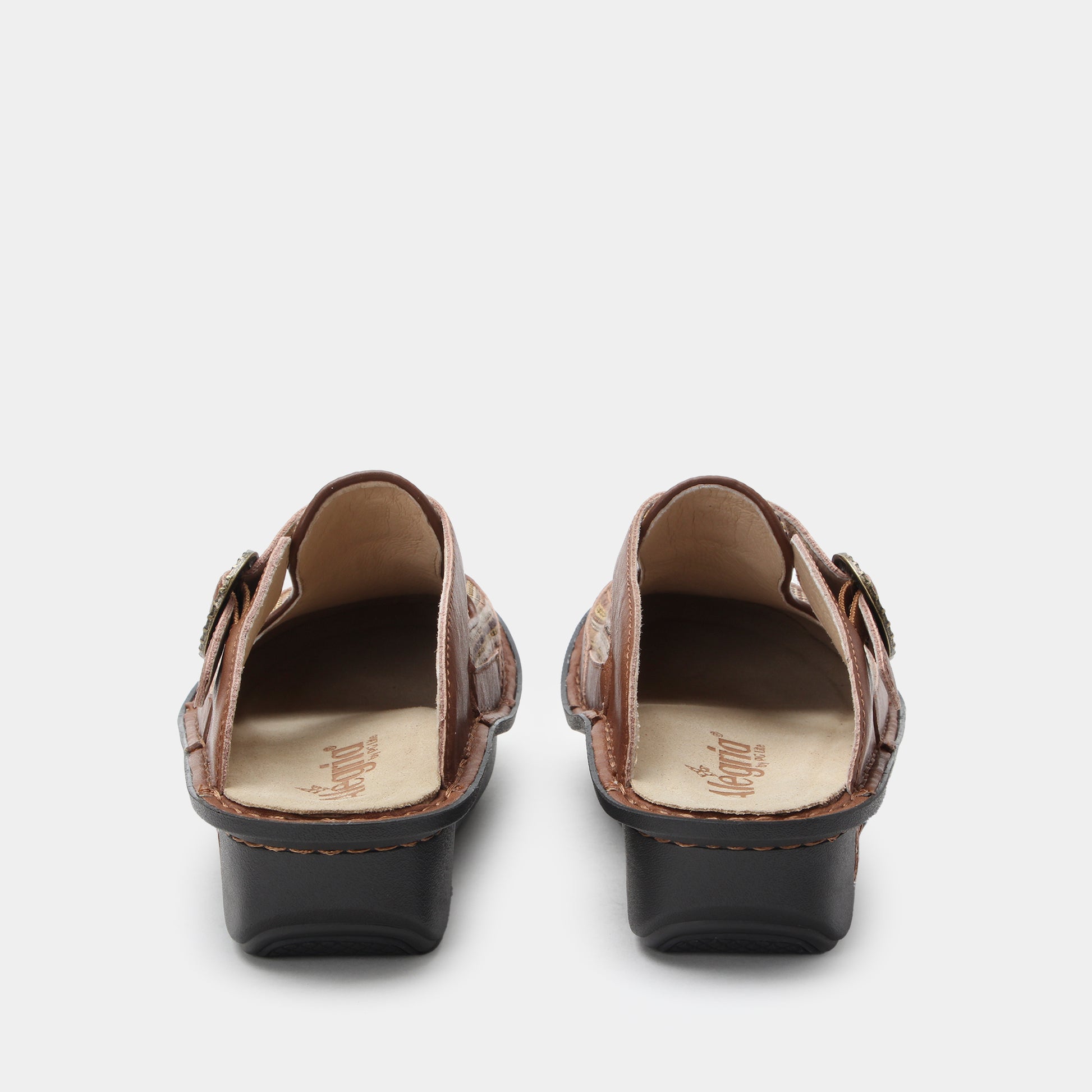 Pair of brown clogs with buckles on a white background