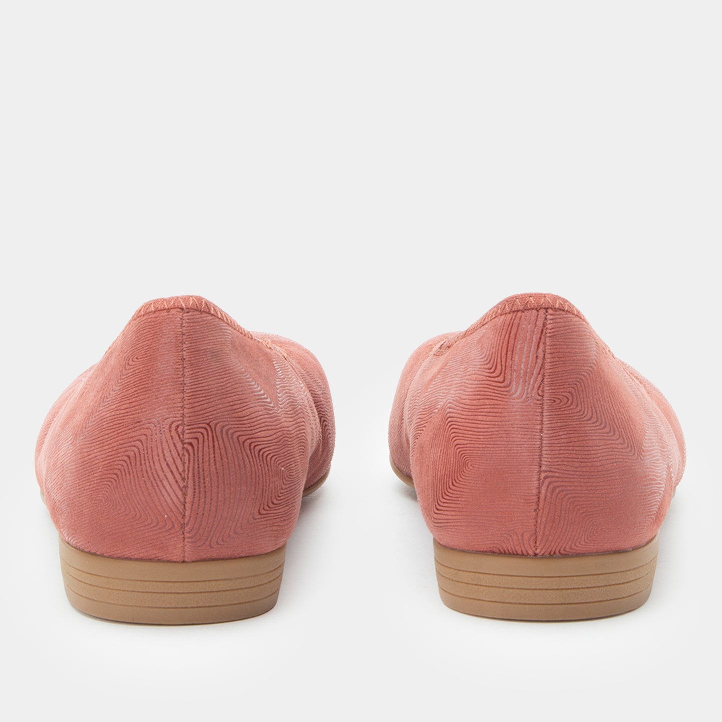 Pair of pink suede shoes with brown soles on a white background