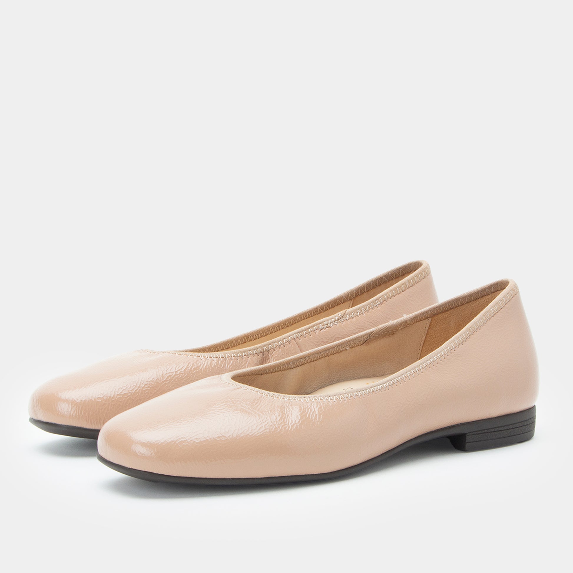 Pair of beige flat shoes on a white background