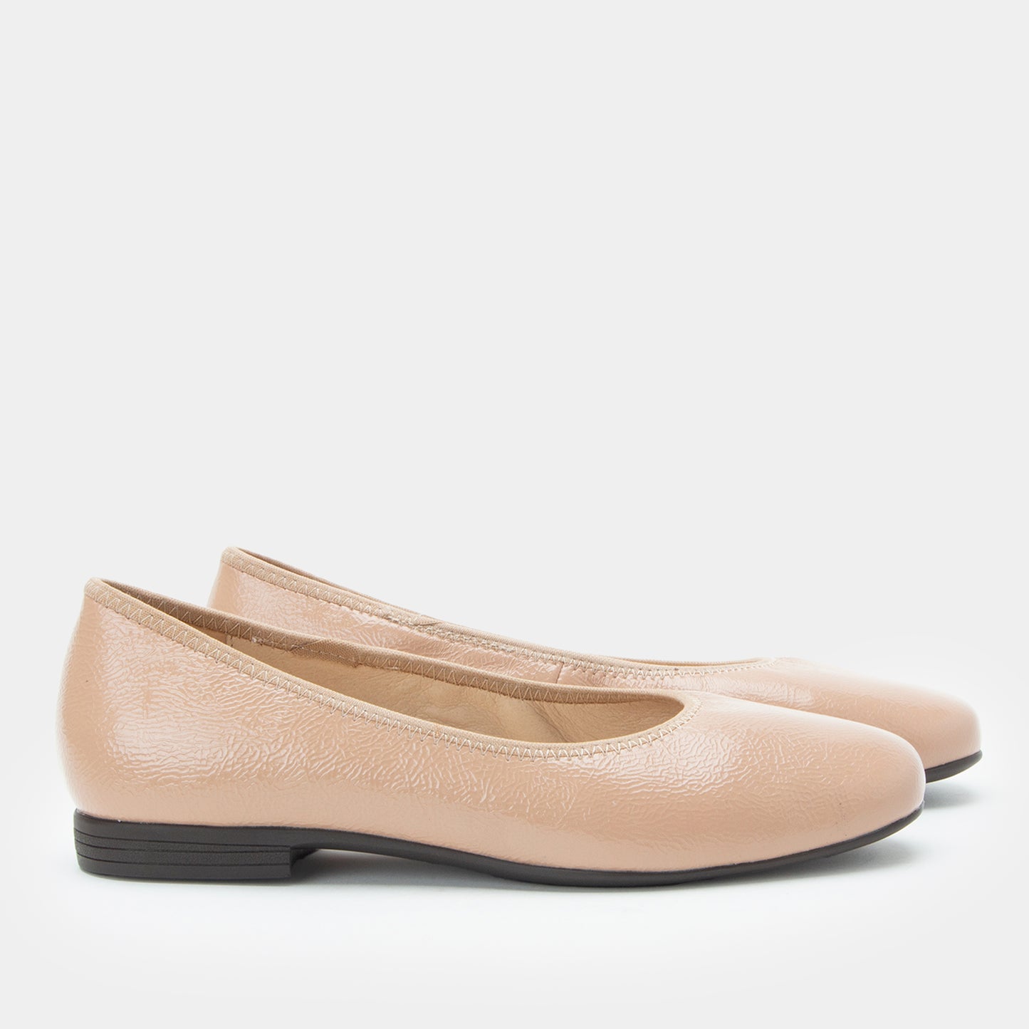 Pair of beige flats on a white background