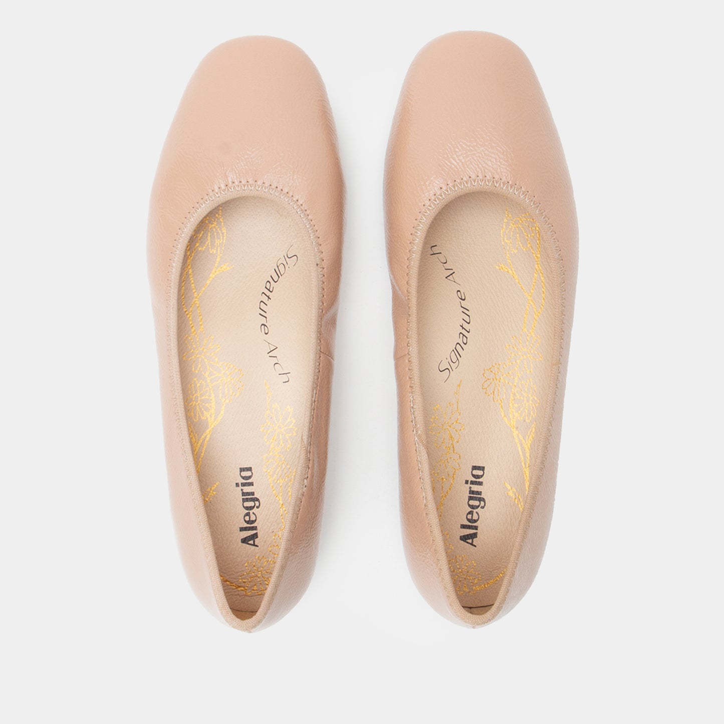 Pair of beige Alegria shoes on a white background