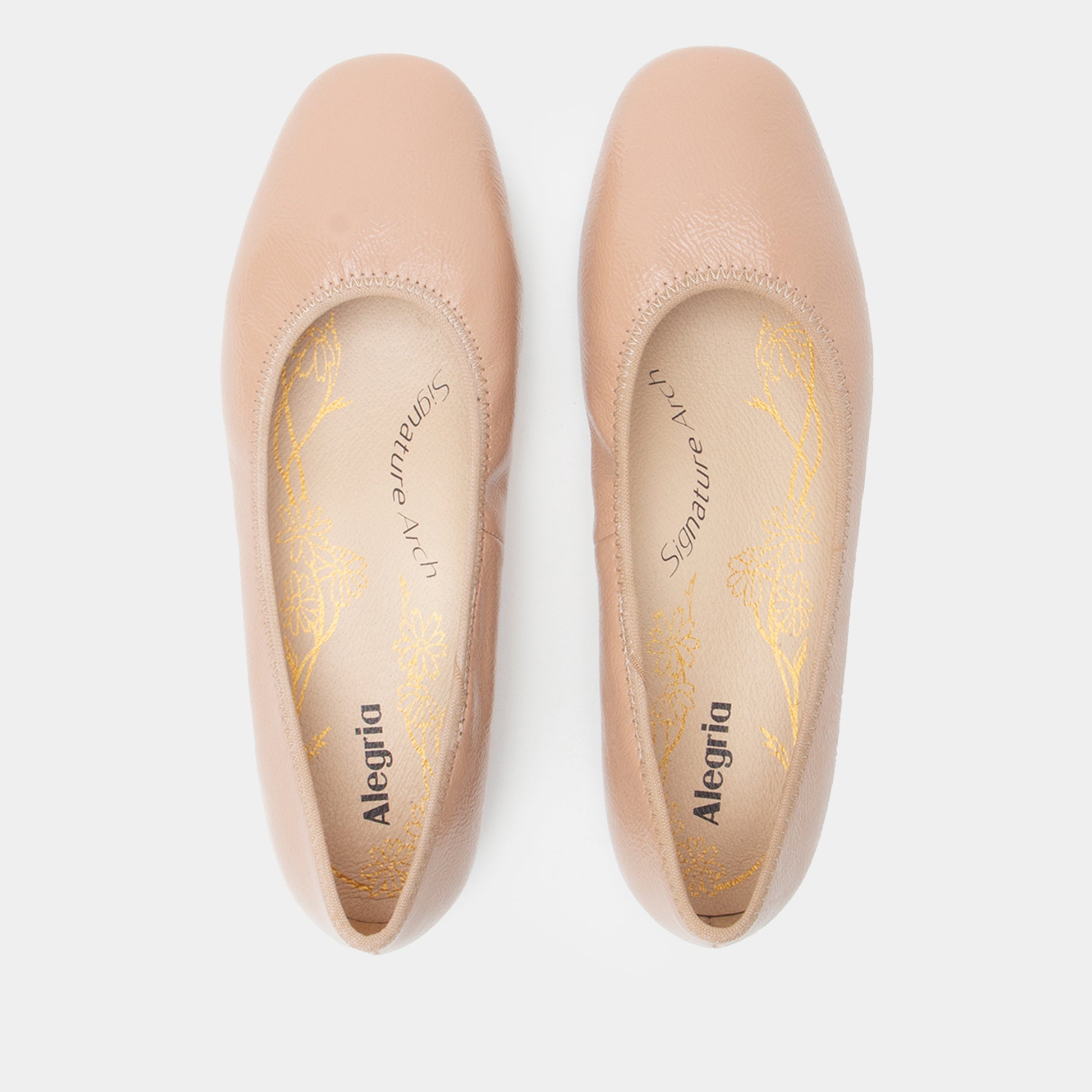 Pair of beige Alegria shoes on a white background