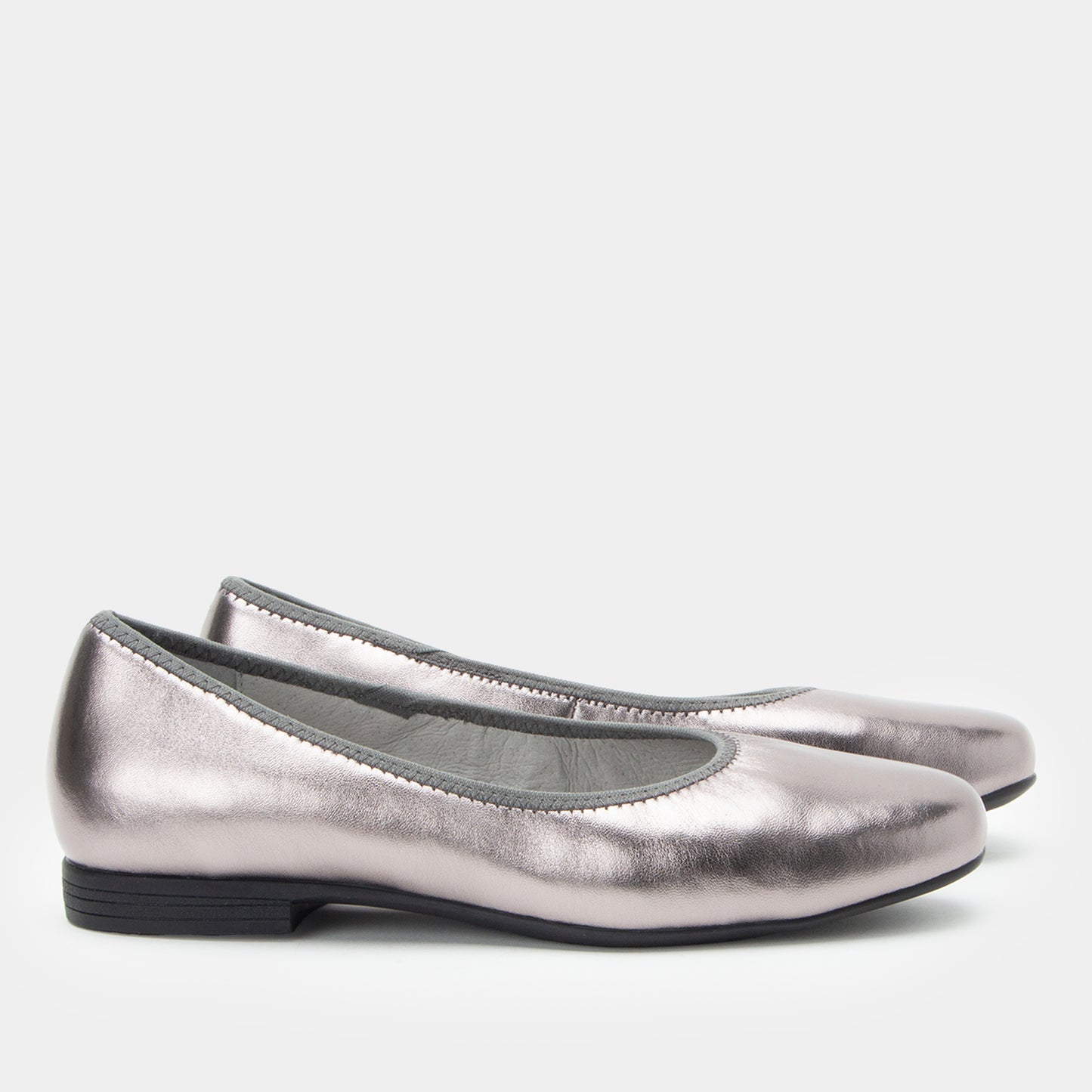 Pair of silver metallic flats on a white background