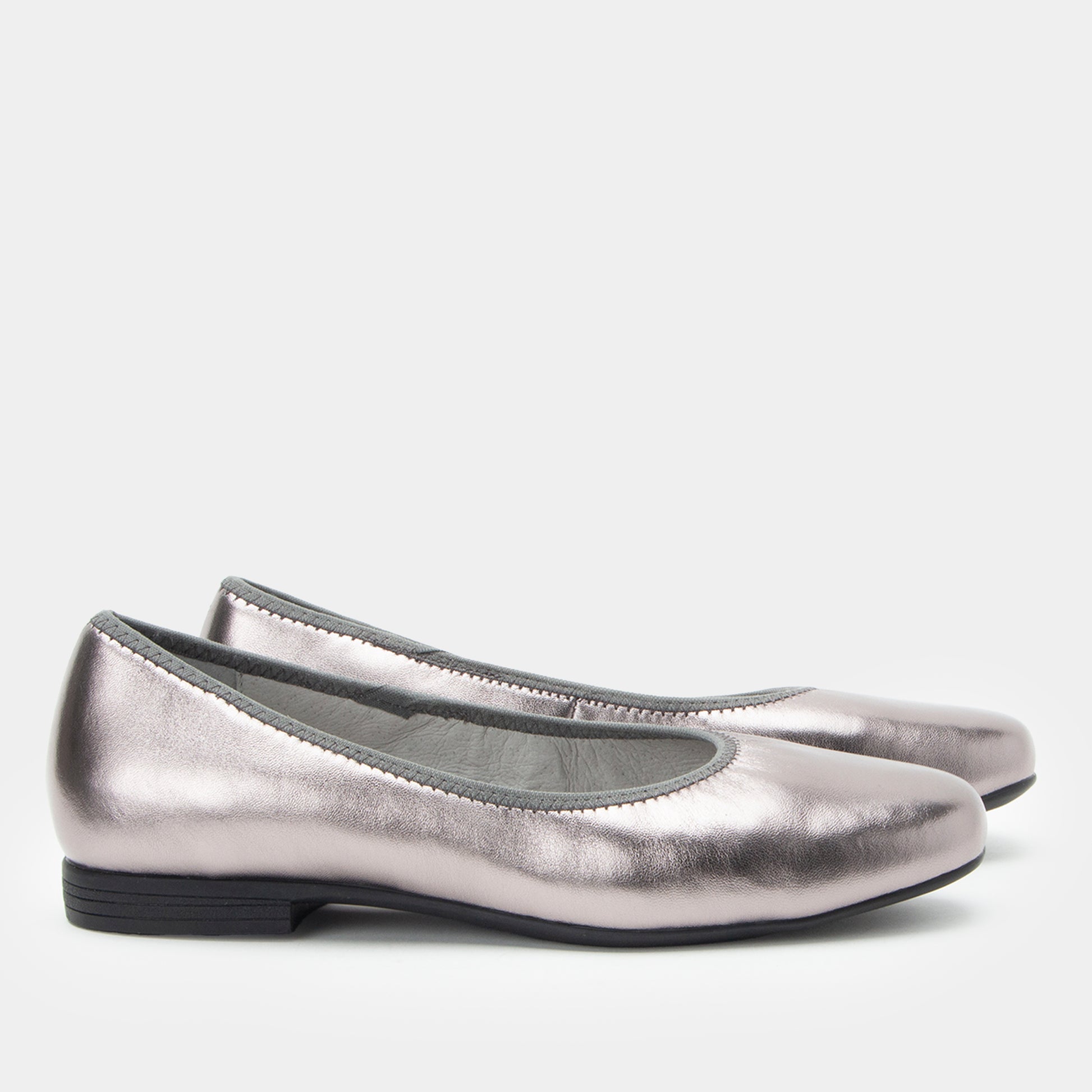 Pair of silver metallic flats on a white background