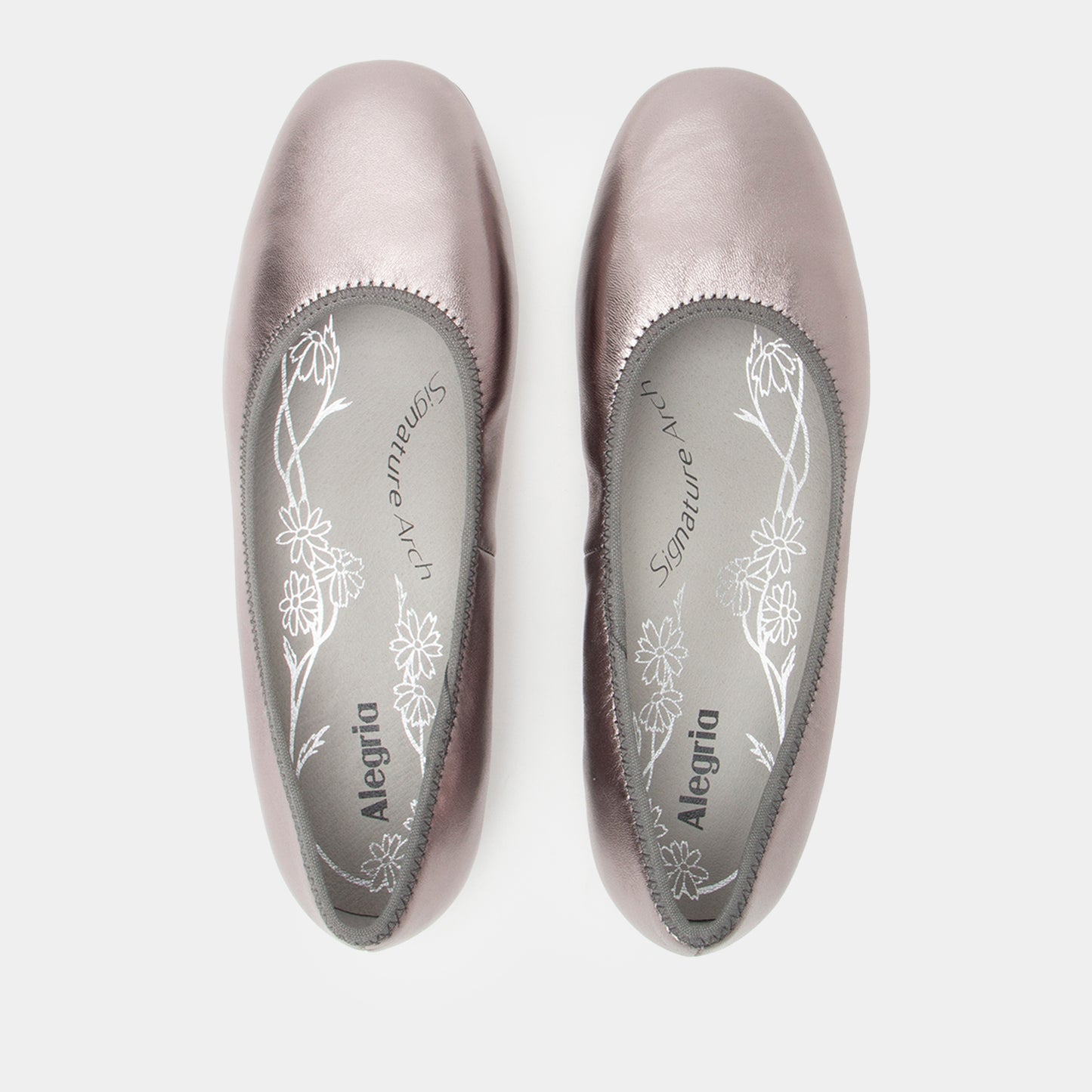 Pair of silver ballet flats with floral design on a white background