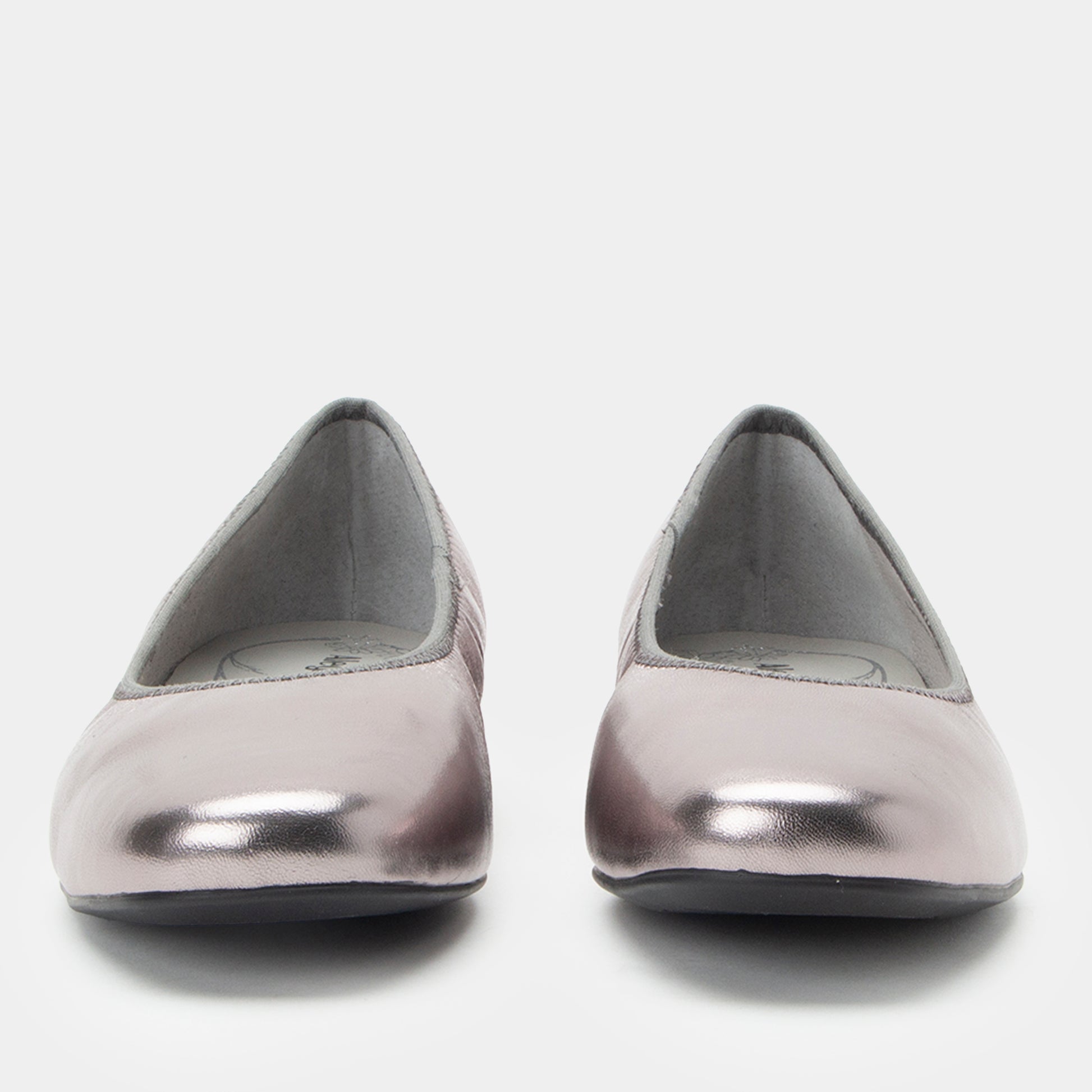 Pair of silver metallic flats on a white background