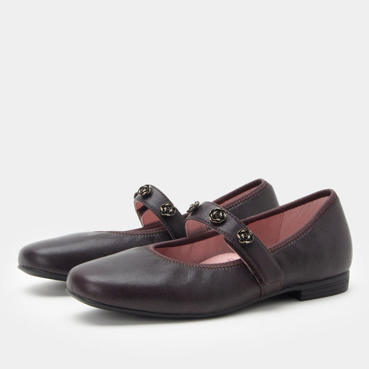 Pair of dark purple shoes with buckles on a light gray background
