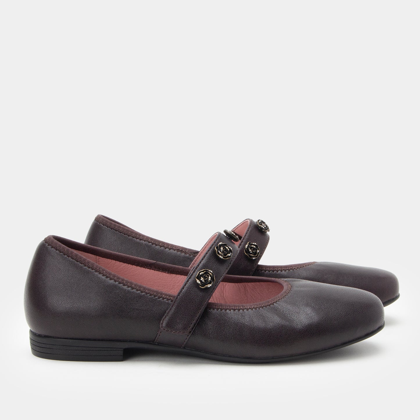 Pair of dark brown leather shoes with a strap on a light gray background
