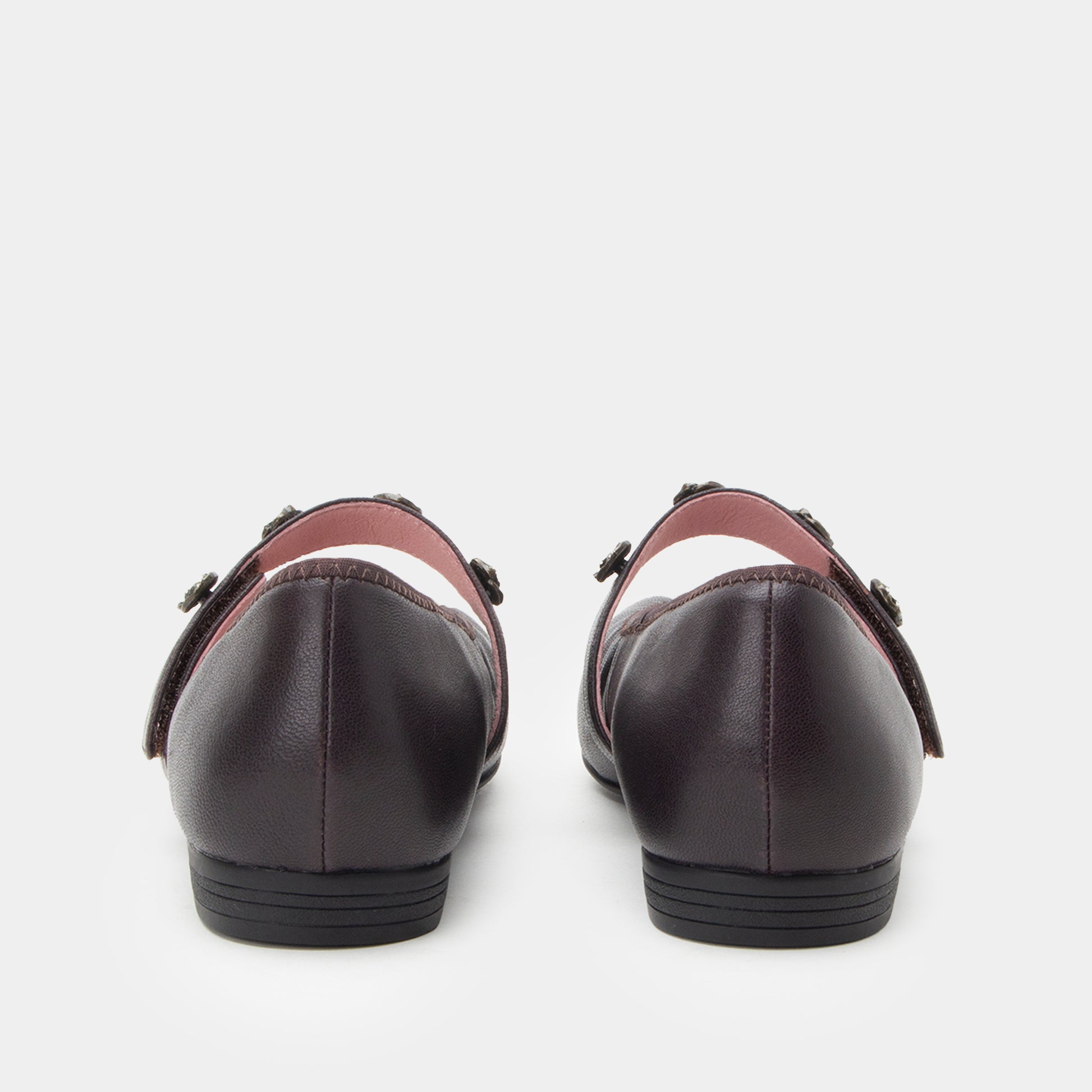 Pair of black leather shoes with brown accents on a white background