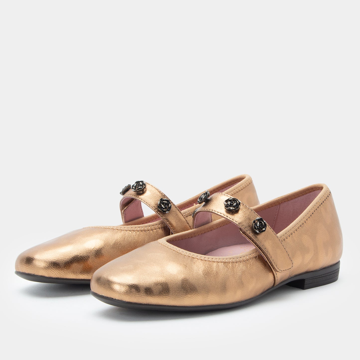Pair of gold shoes with black straps on a white background