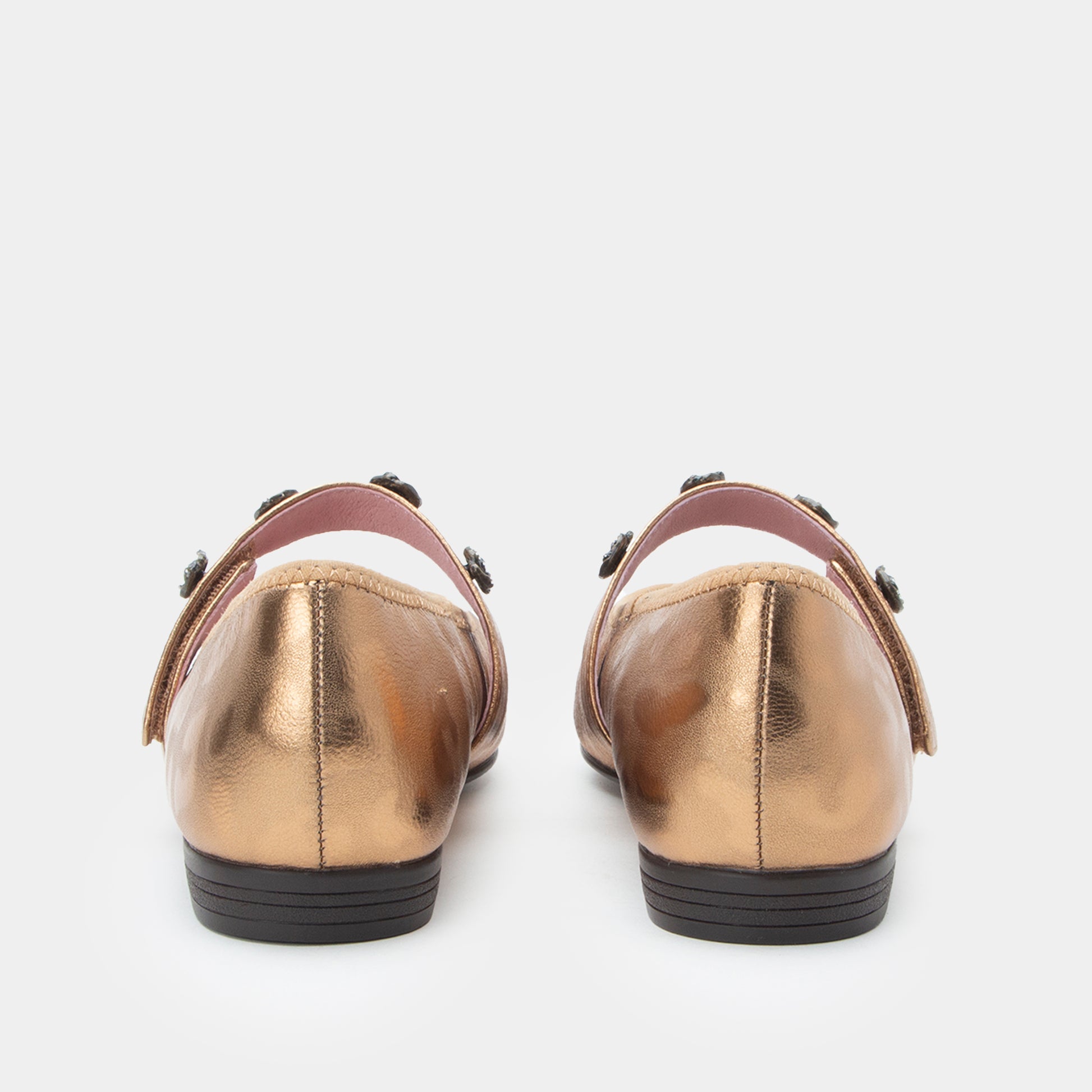 Pair of gold metallic shoes on a white background