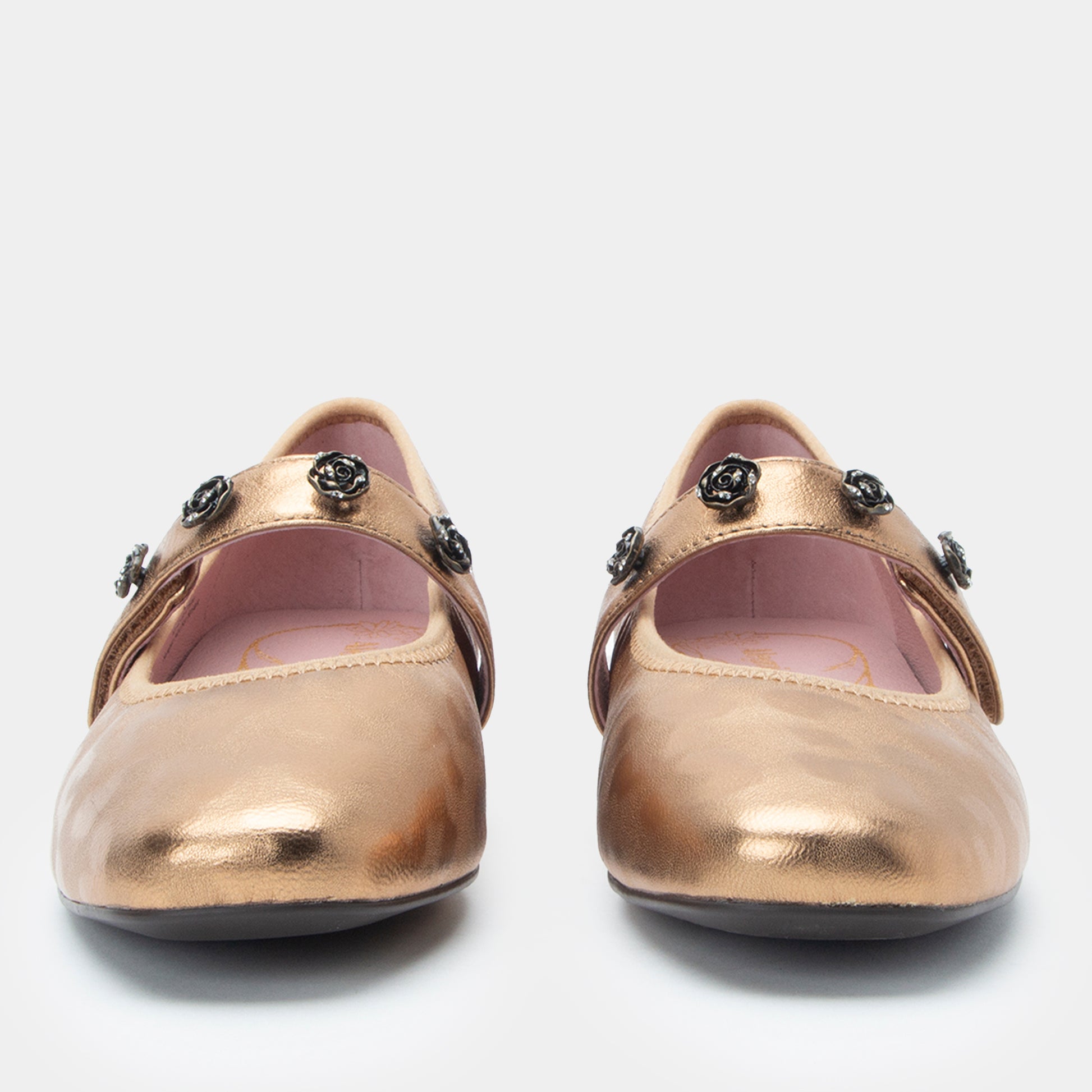 Pair of gold shoes with decorative elements on a white background