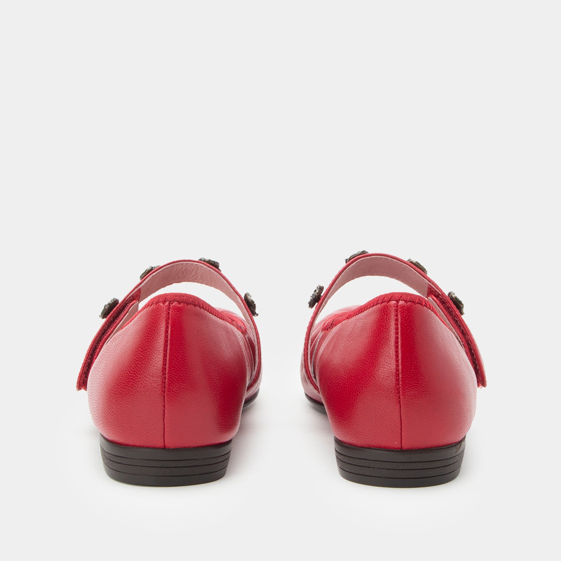 Pair of red shoes with black soles on a white background