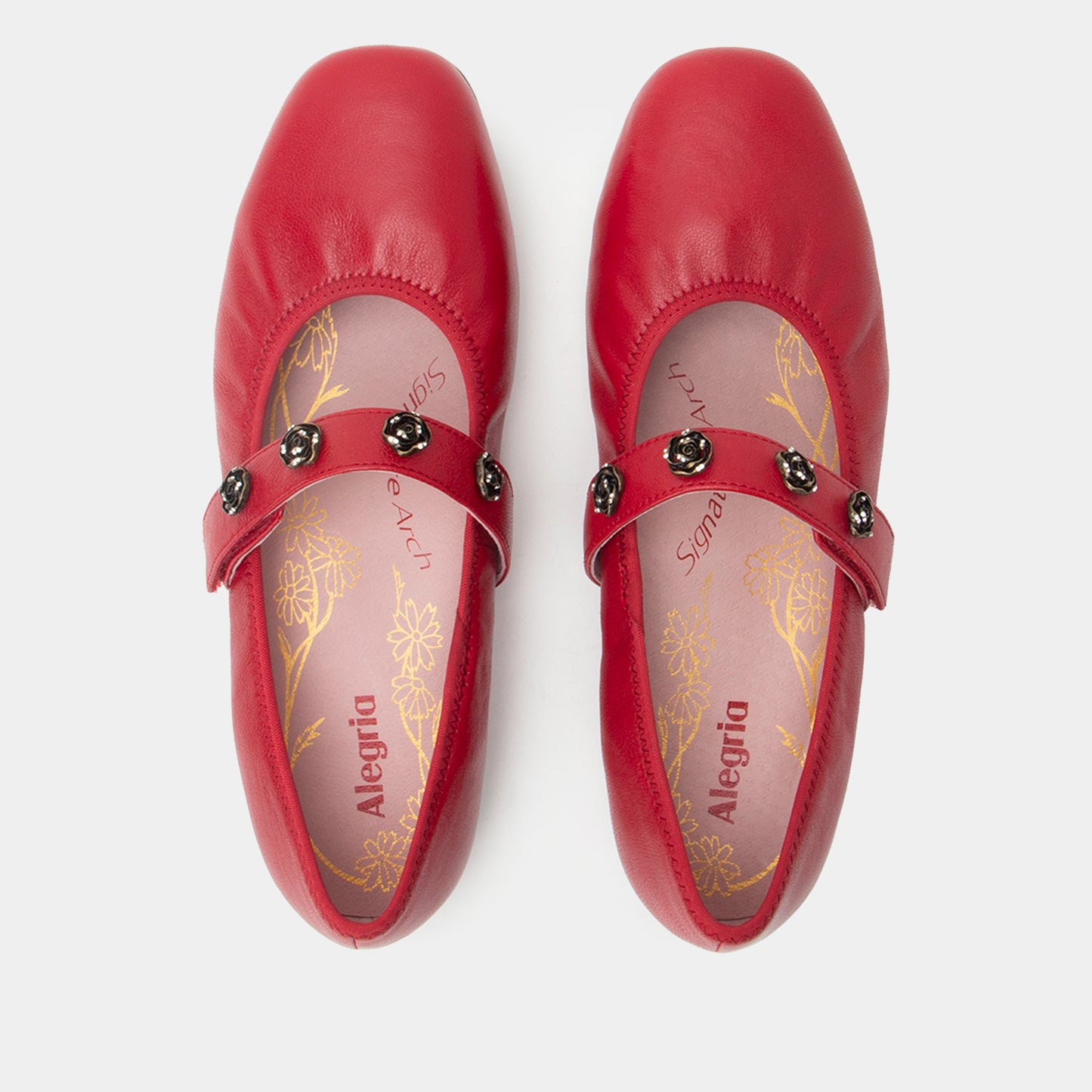 Pair of red shoes with decorative straps on a white background