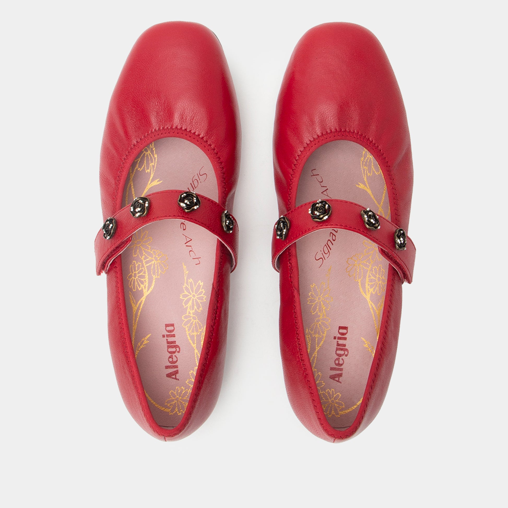 Pair of red shoes with decorative straps on a white background