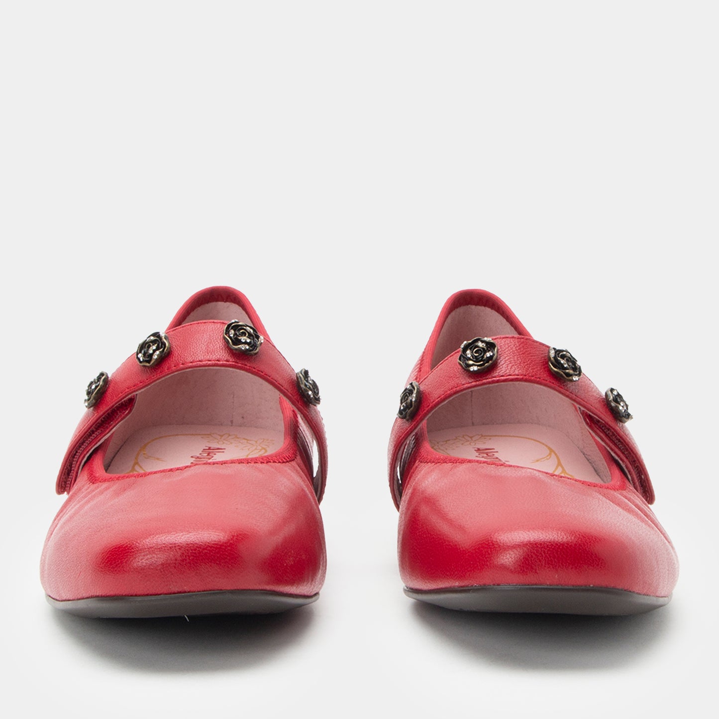 Pair of red shoes with decorative straps on a white background