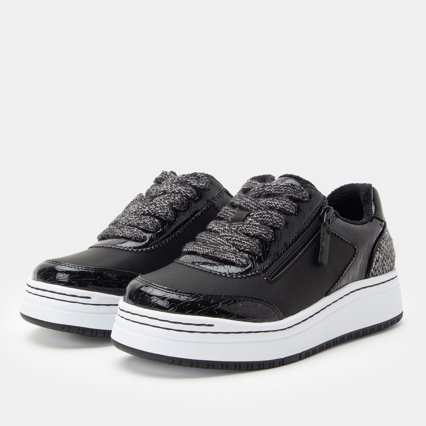 Black sneakers with white soles on a light gray background