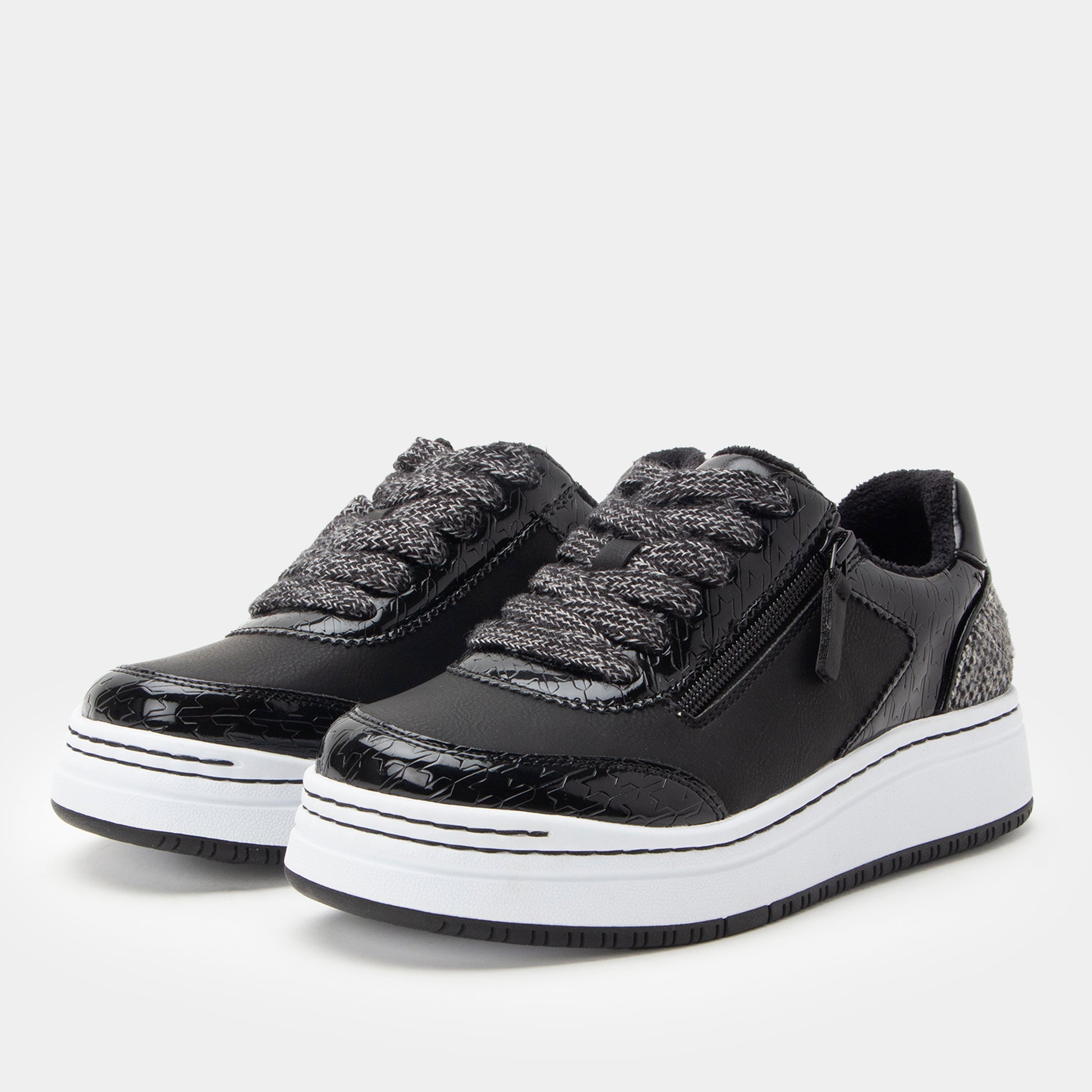 Black sneakers with white soles on a light gray background