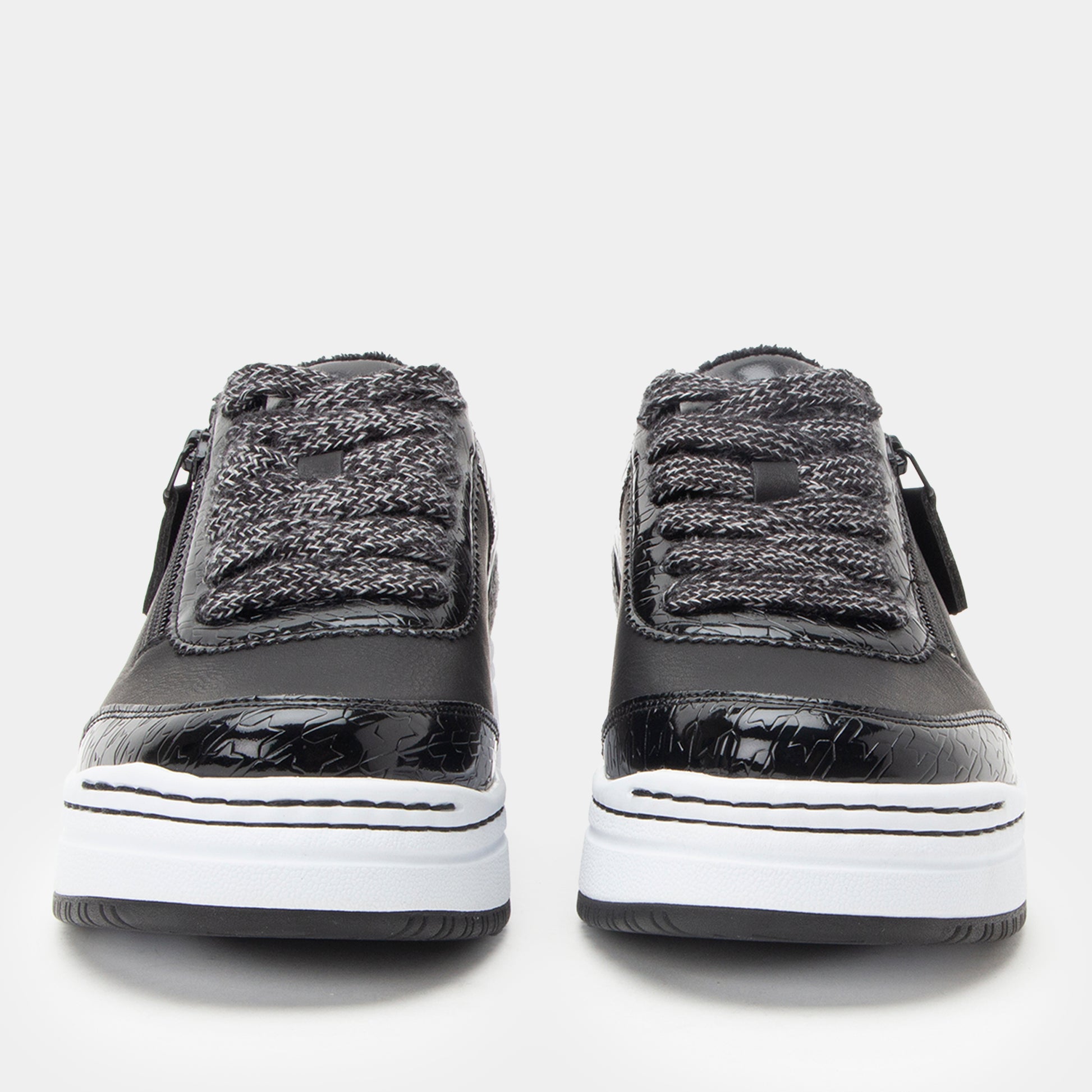 Black and gray sneakers with white soles on a light gray background