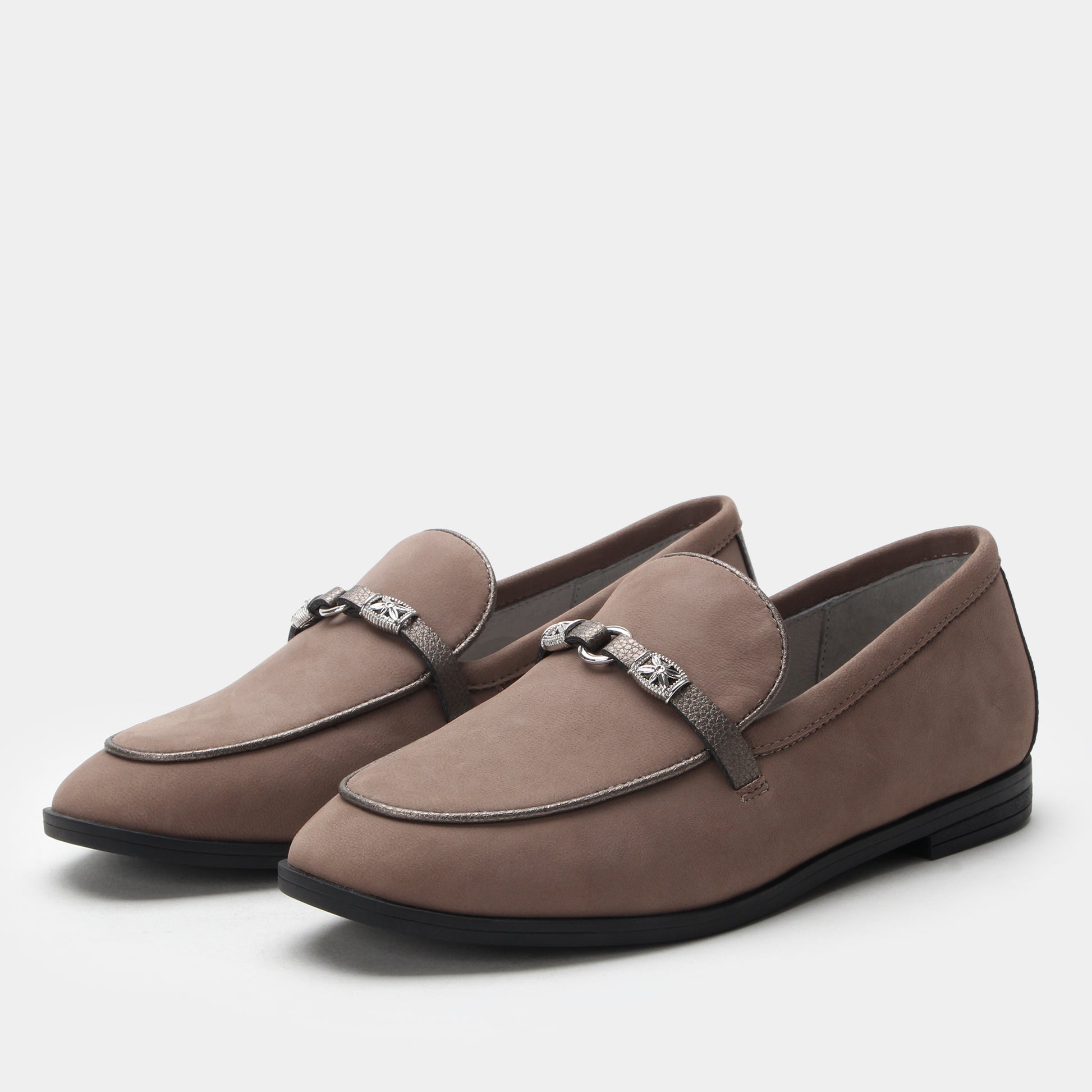 Pair of brown loafers with decorative buckles on a light gray background