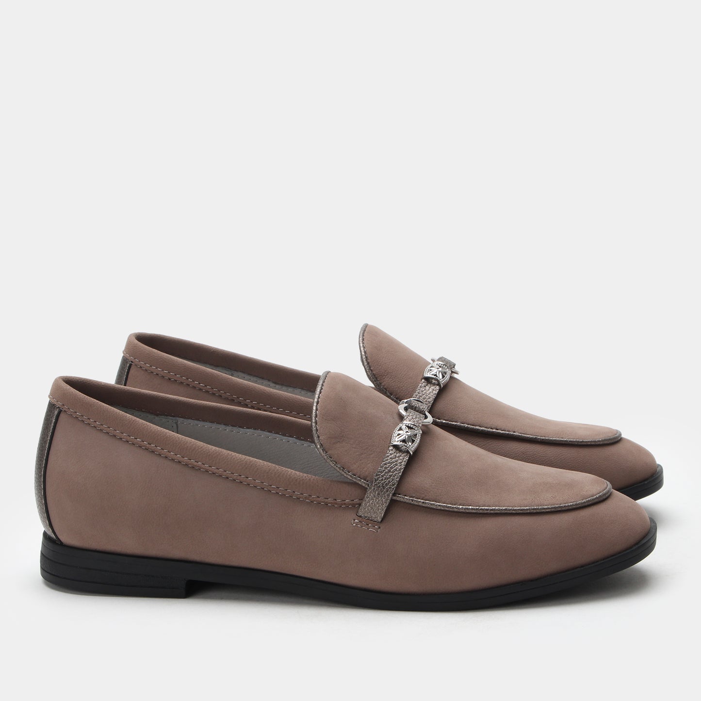 Pair of brown loafers with a decorative strap on a white background