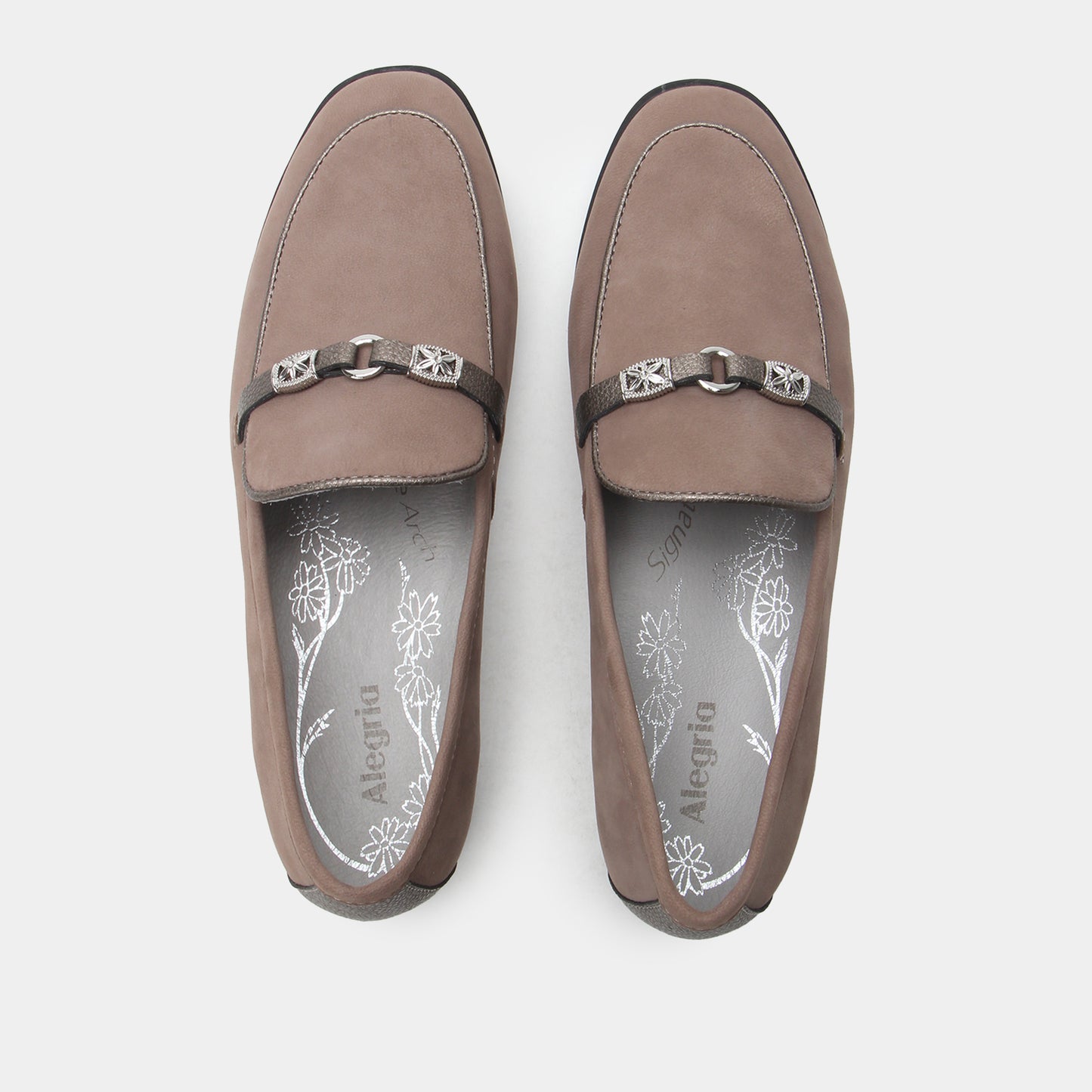 Pair of brown loafers with decorative straps on a white background