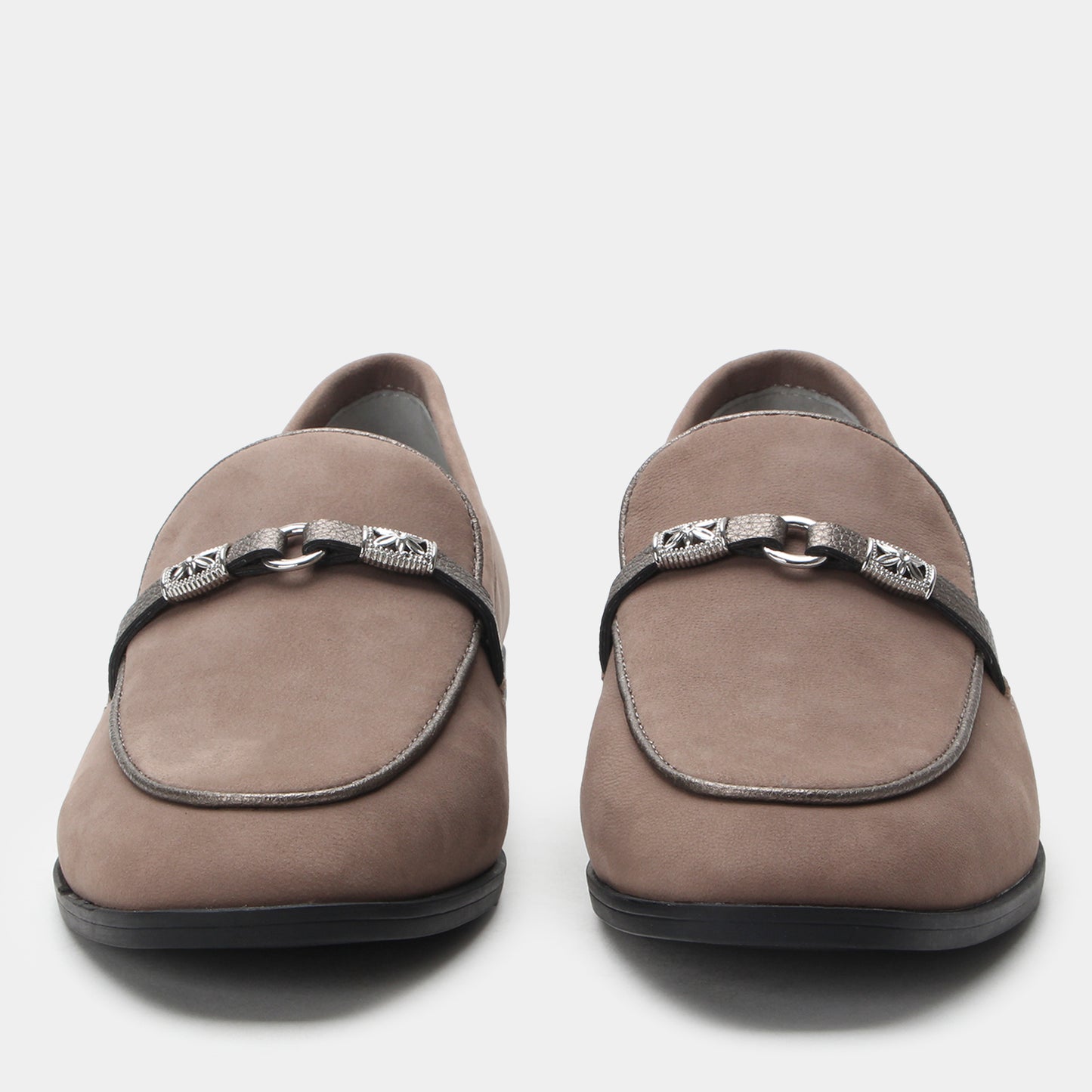 Pair of brown loafers with decorative straps on a white background