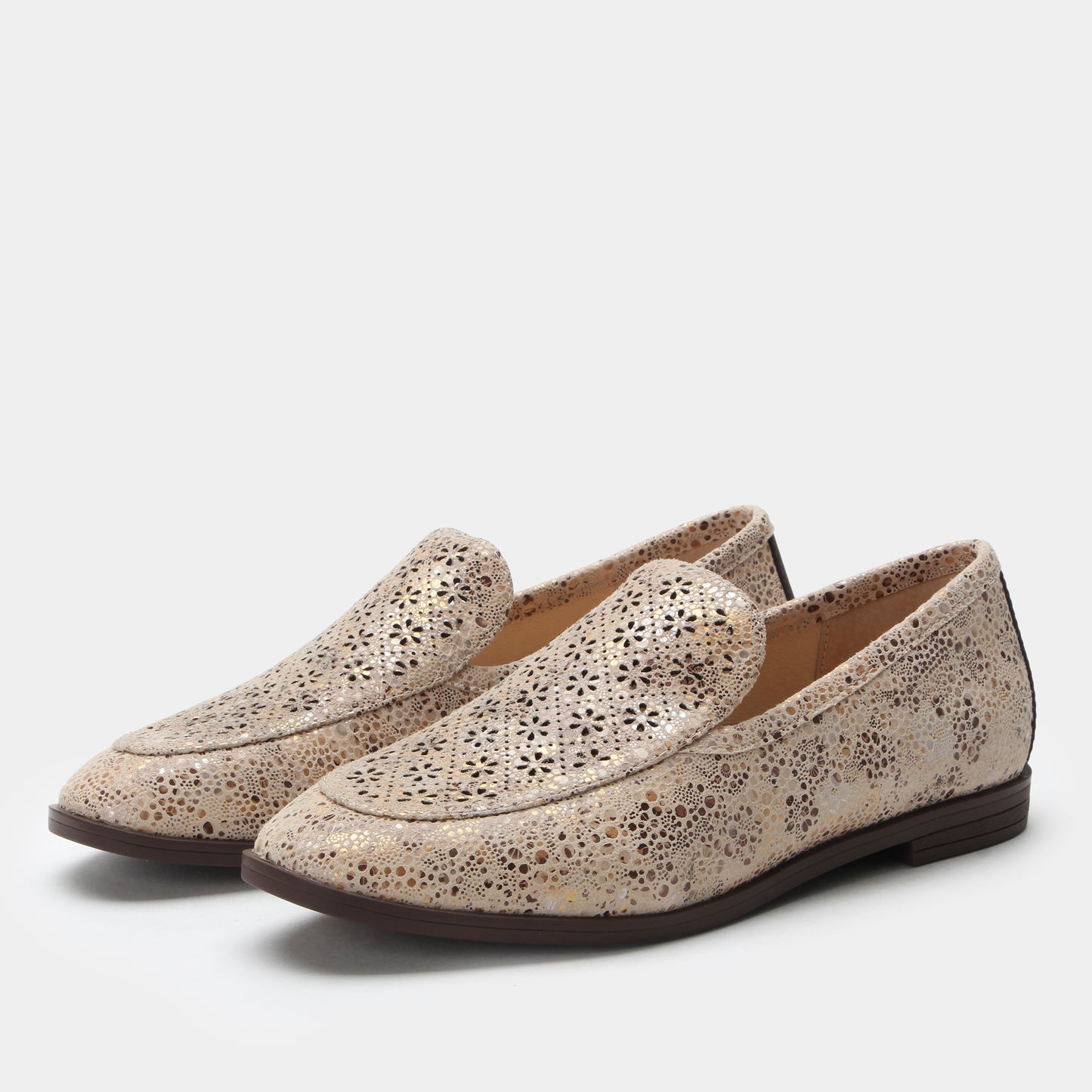 Pair of beige loafers with a subtle pattern on a light gray background