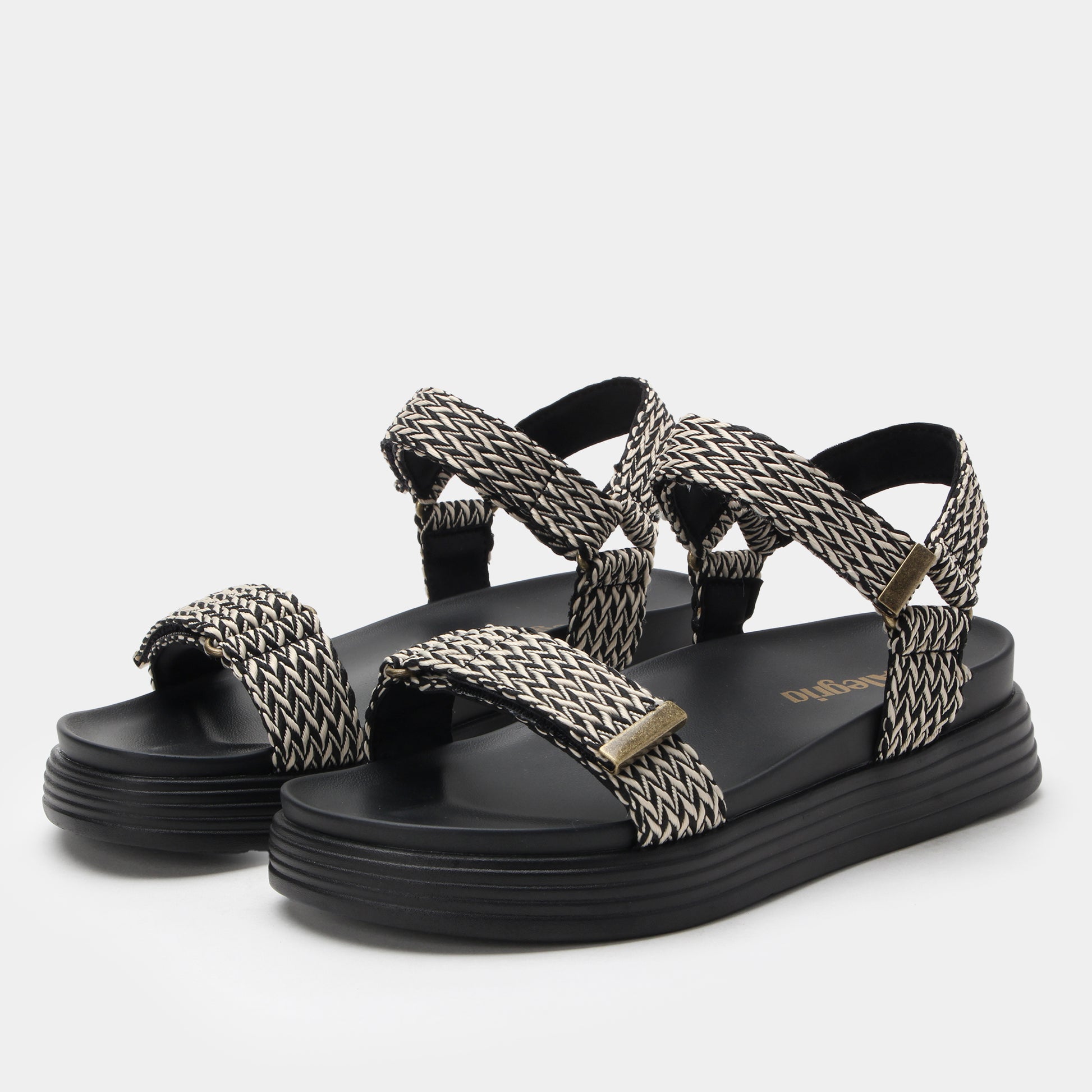 Black and white woven sandals on a light gray background