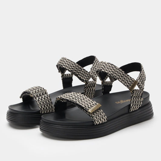 Black and white woven sandals on a light gray background